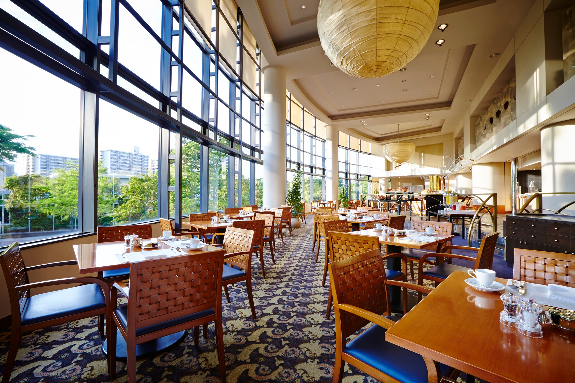 天井まで広がる窓から優しい自然光に包まれる開放的なレストラン