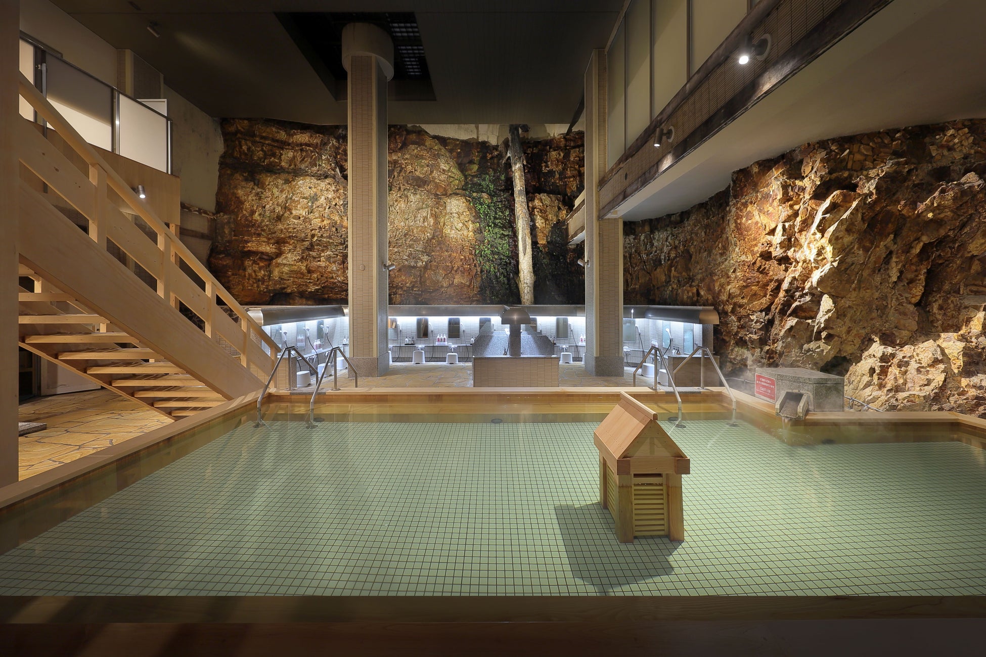 強固な岩壁の前に浴槽がある、野趣溢れる設え