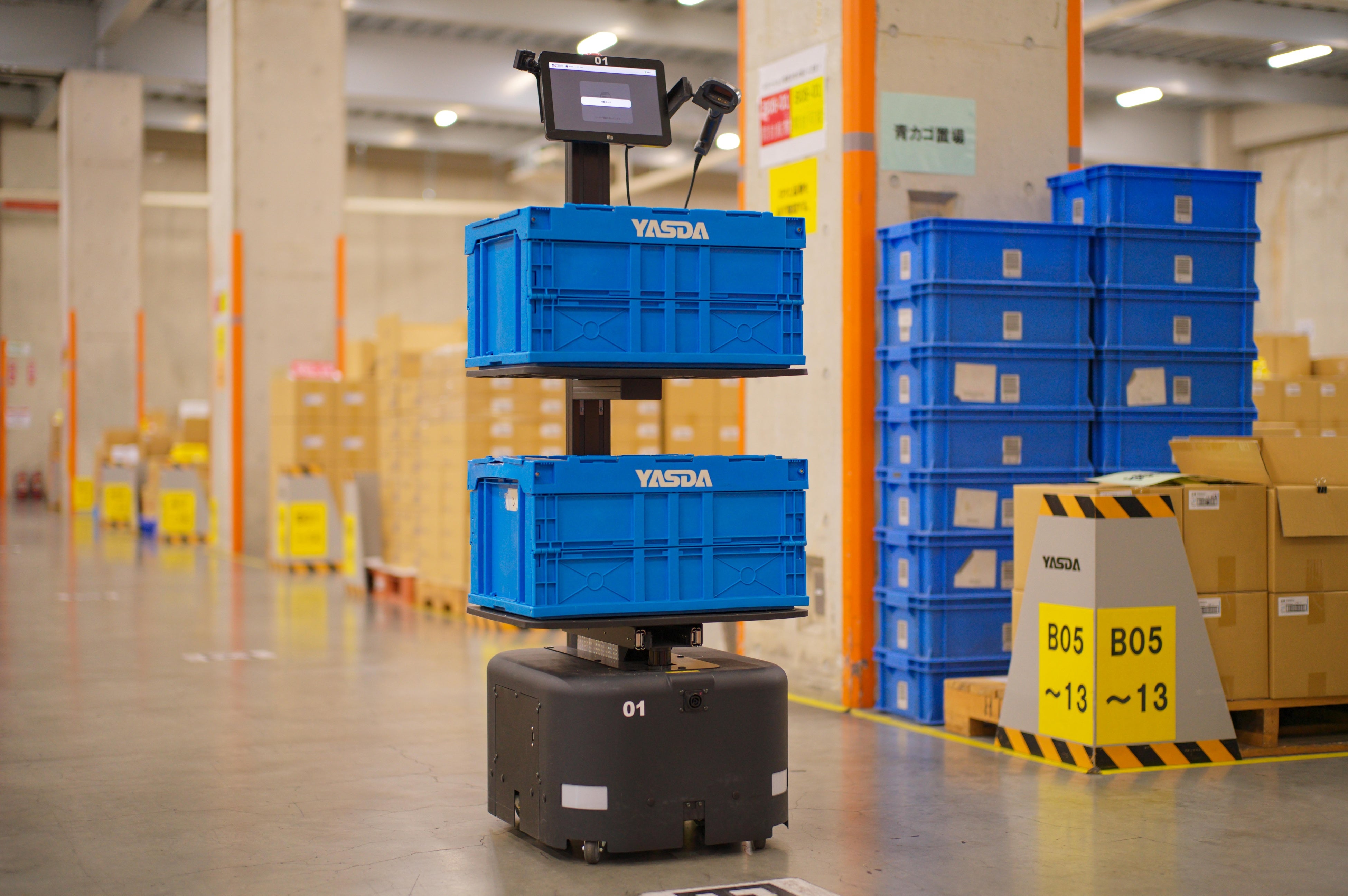 写真：作業員と協働するピッキングアシストAMR