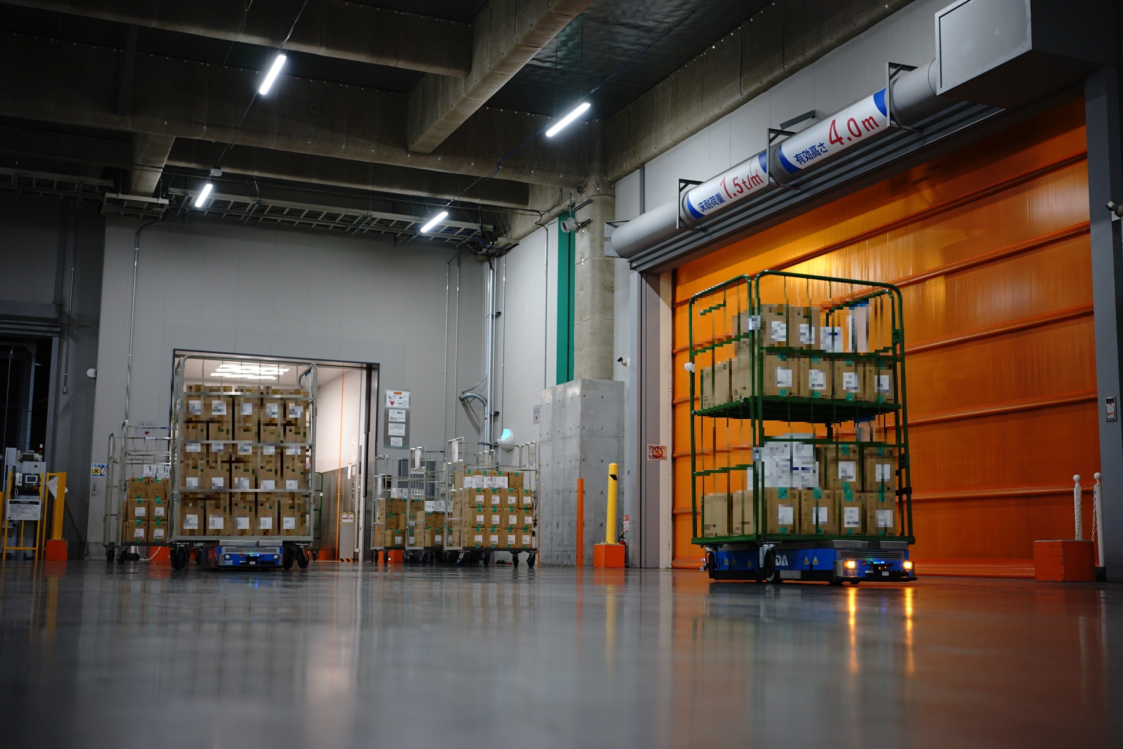 写真：カゴ台車を把持して搬送するロボット