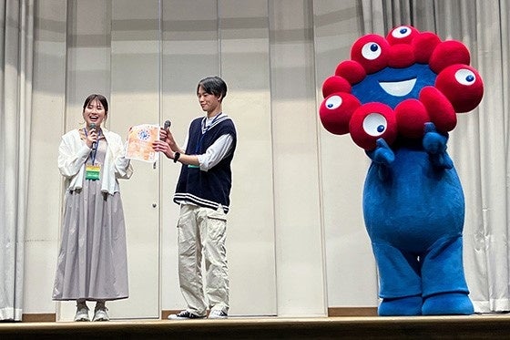 2024 年 4 月の新歓イベントで、ミャクミャクとコラボ して大阪・関西万博 PR を行う関大万博部の学生