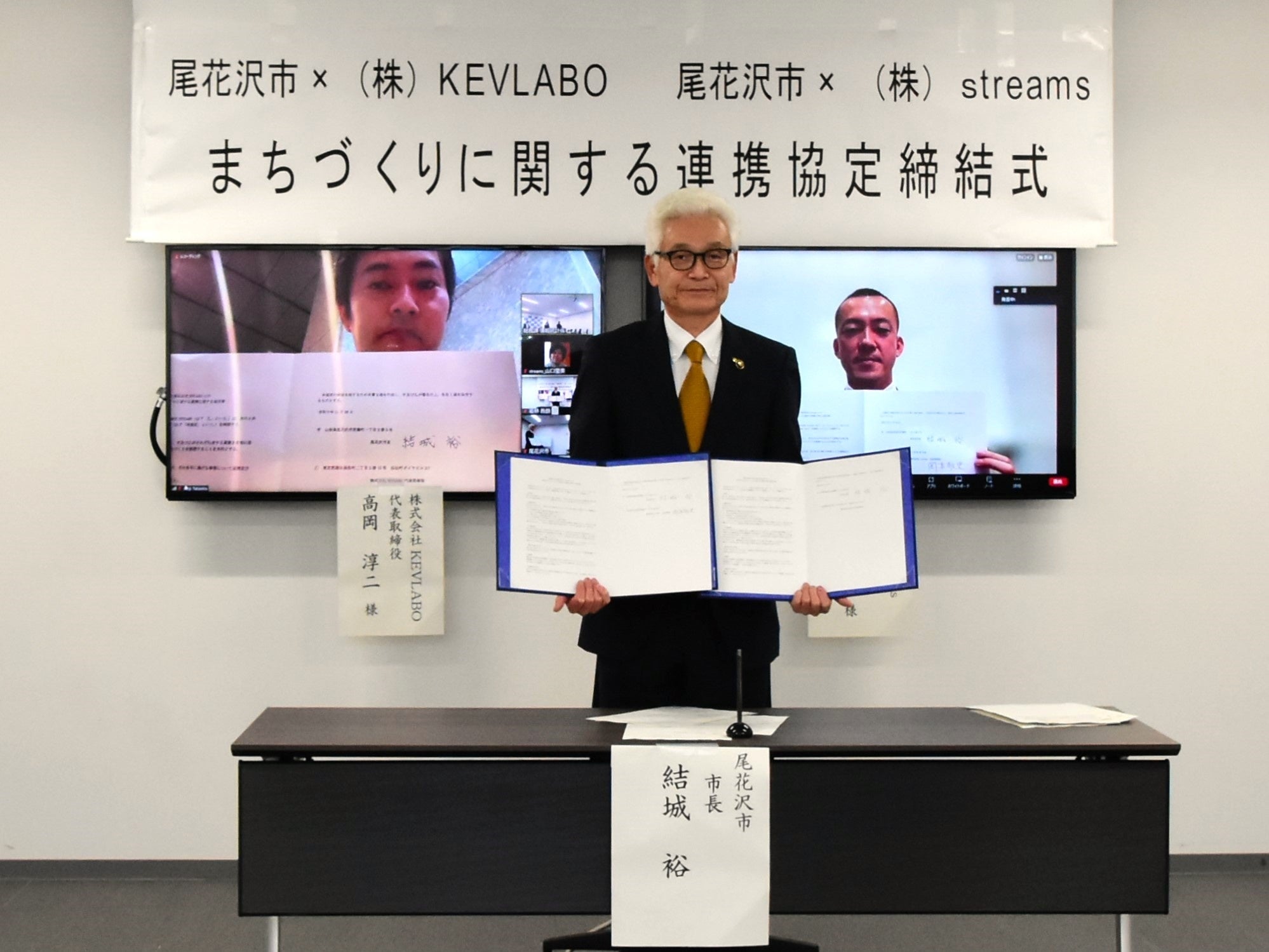 協定締結式の様子（中央が結城市長、右上画面がstreams代表 岡本）