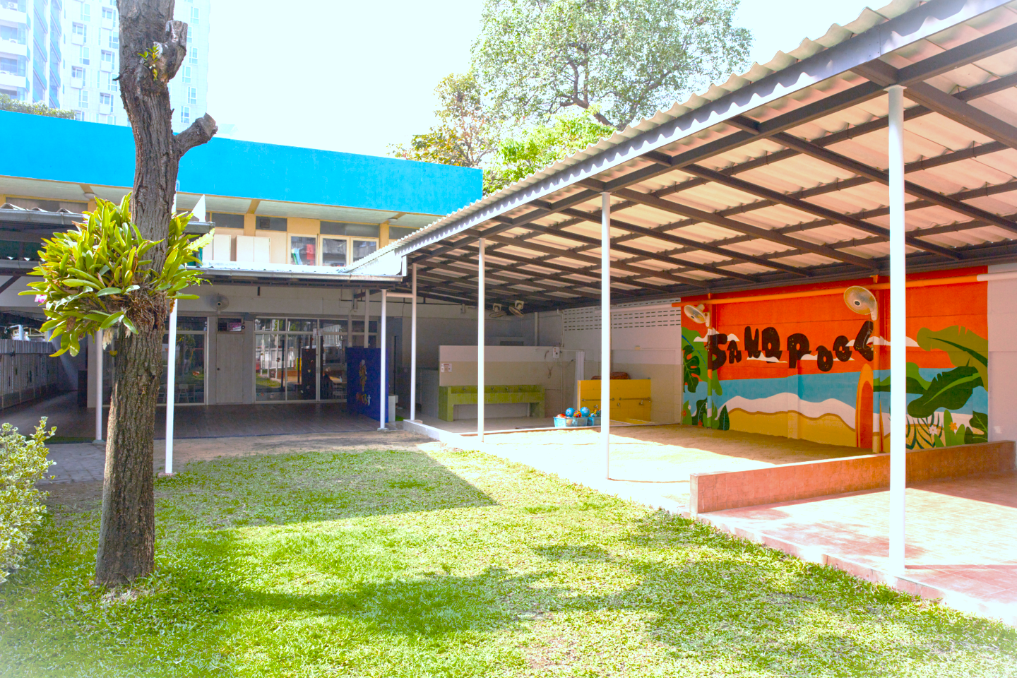 トンロー園：屋根のある砂場エリアと園舎