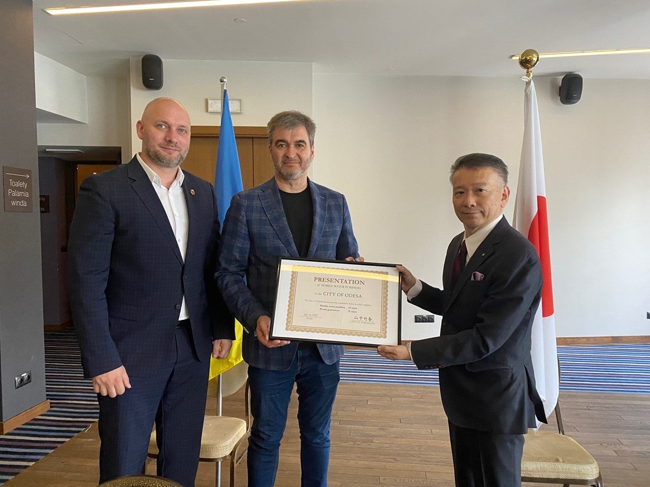 オデーサ市副市長への目録贈呈（左から：ドミトロ副市長、セルギー副市長、横浜市赤岡理事）