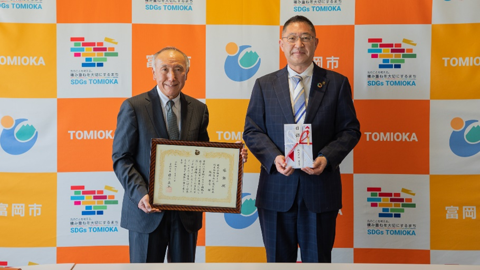 榎本市長（右）より感謝状を受け取るヨコオ徳間社長