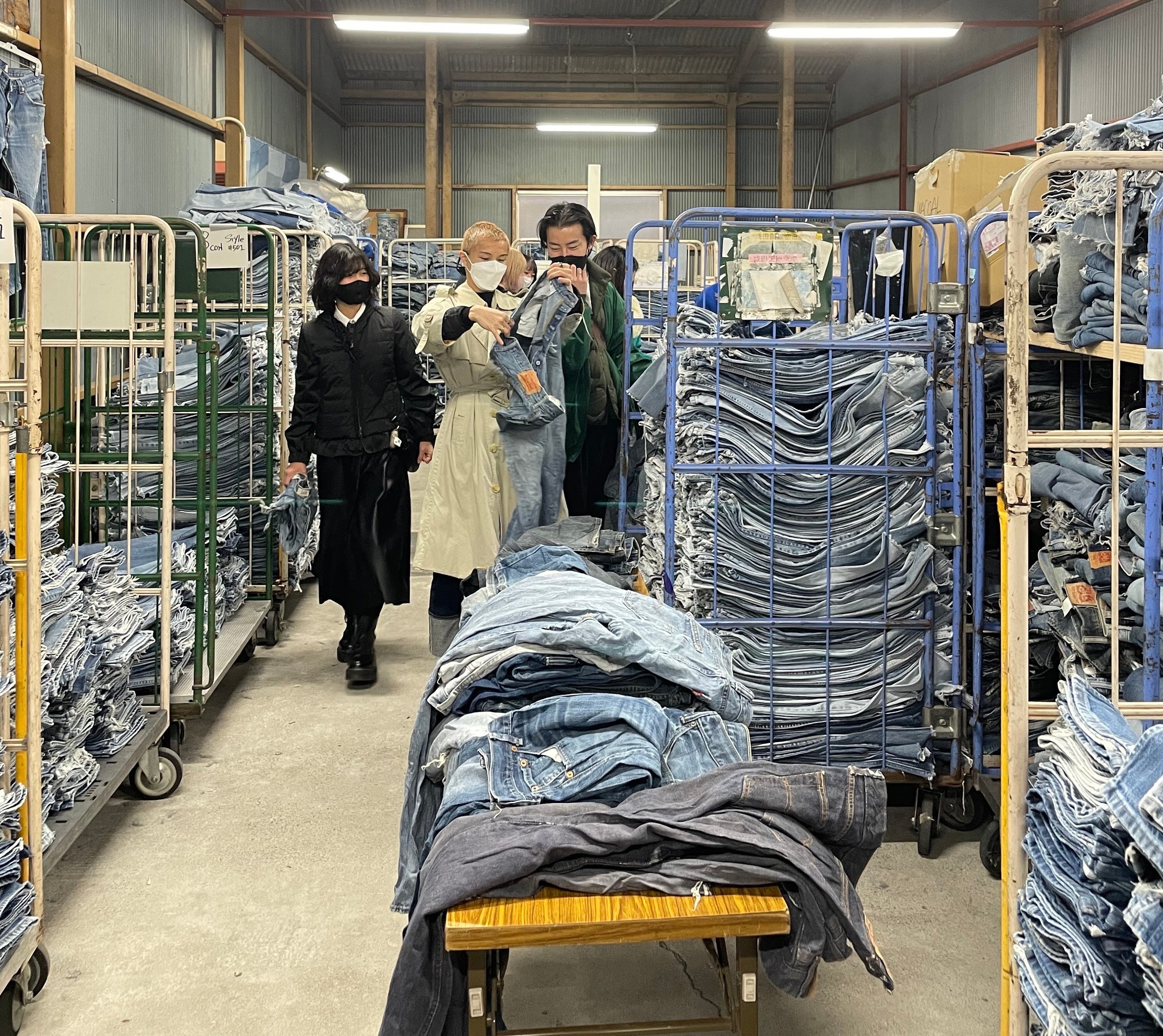 ヤマサワプレスの倉庫でデニムを選ぶ様子　