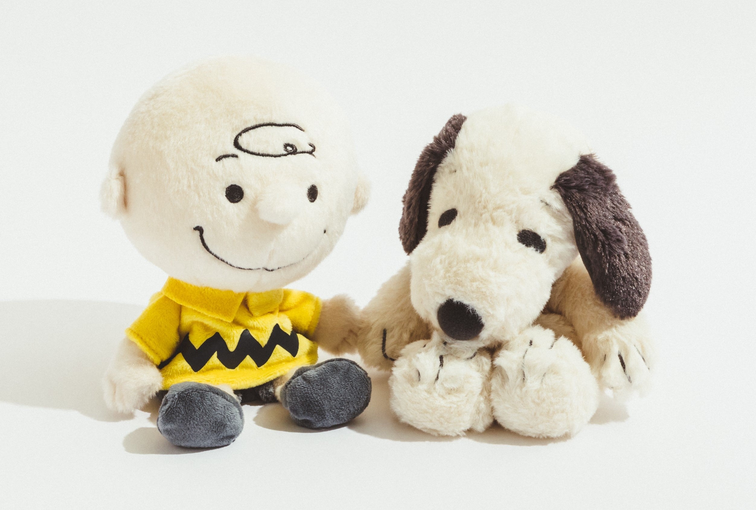 ゆるくたぬいぐるみ （左）チャーリーブラウン3,300円、 （右）スヌーピー（グレー）2,750円 ※ともに高さ15cm（座った状態）