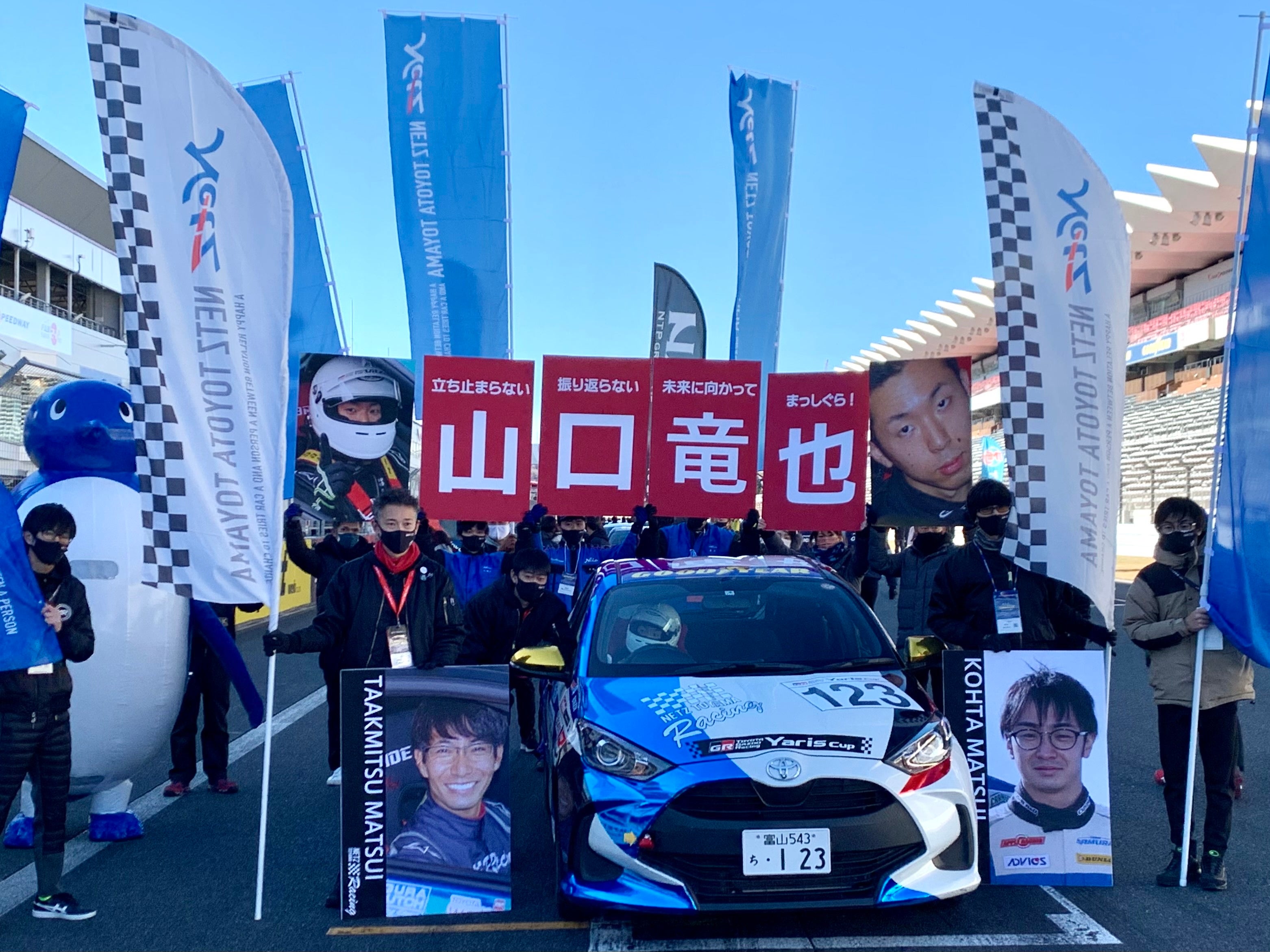 決勝スタートグリッドの様子。ドライバーのパネルや旗を持ったチームスタッフが集合。