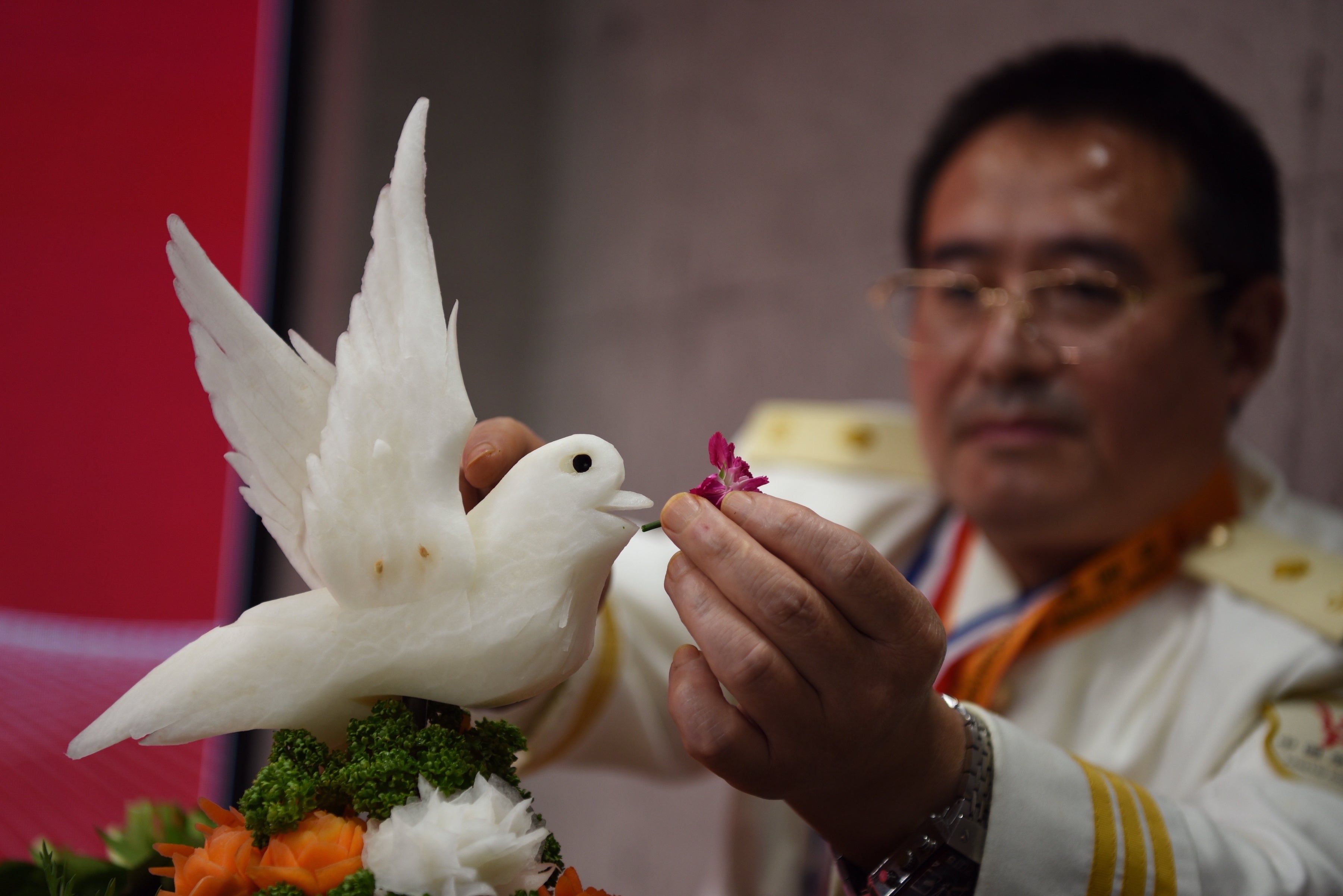 グルメイベント「日本における遼寧の味」の開幕式で、野菜の彫刻を披露する王建華氏。東京都内で（2022年11月18日撮影）。(c)AFPBB News
