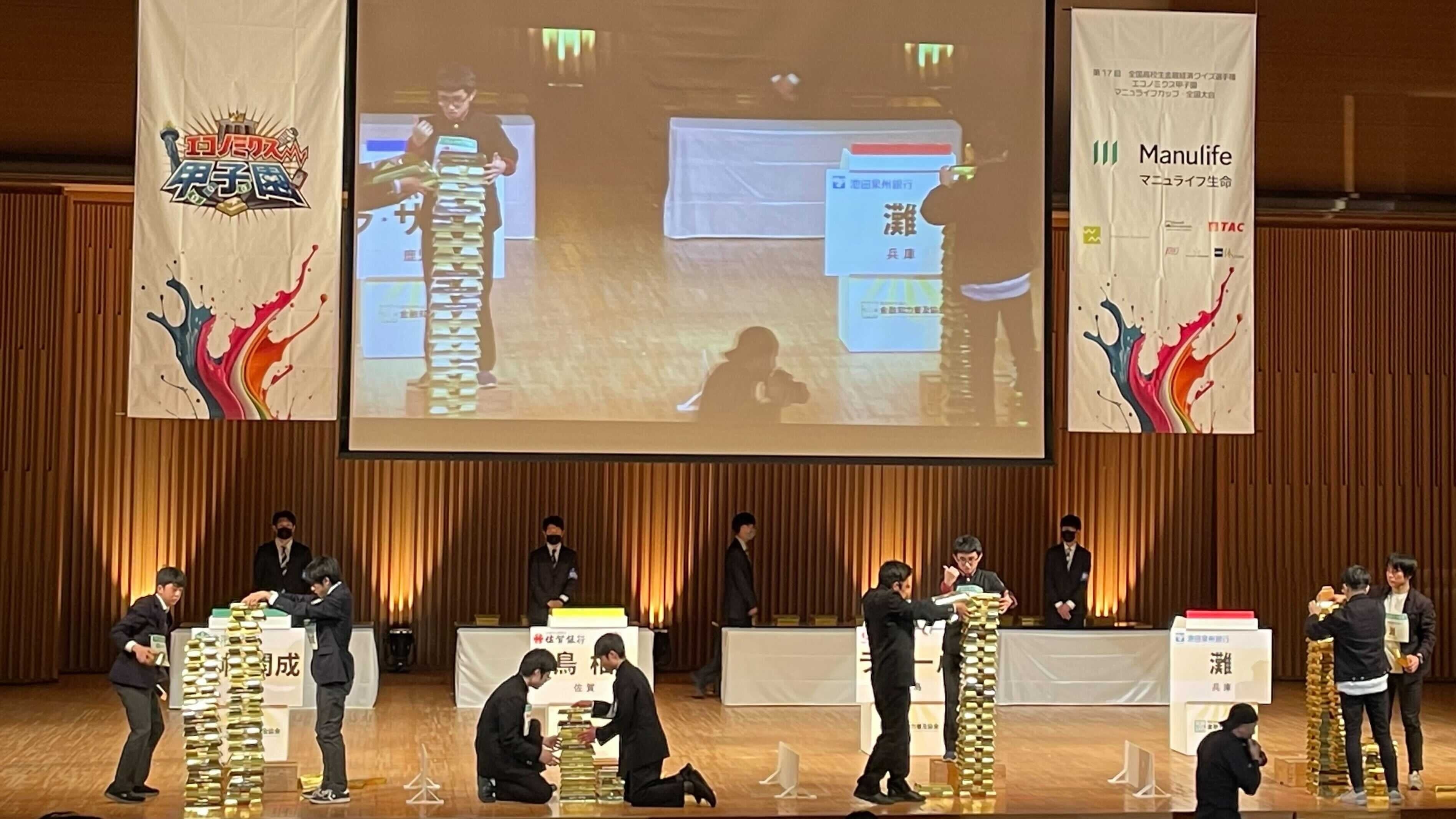 金融知力だけでなくチームワークなども問われた決勝ラウンド。正解した際に与えられる金塊を積み上げる（左から）市立札幌開成中等教育学校、鳥栖高校、ラ・サール高校、灘高校の生徒たち