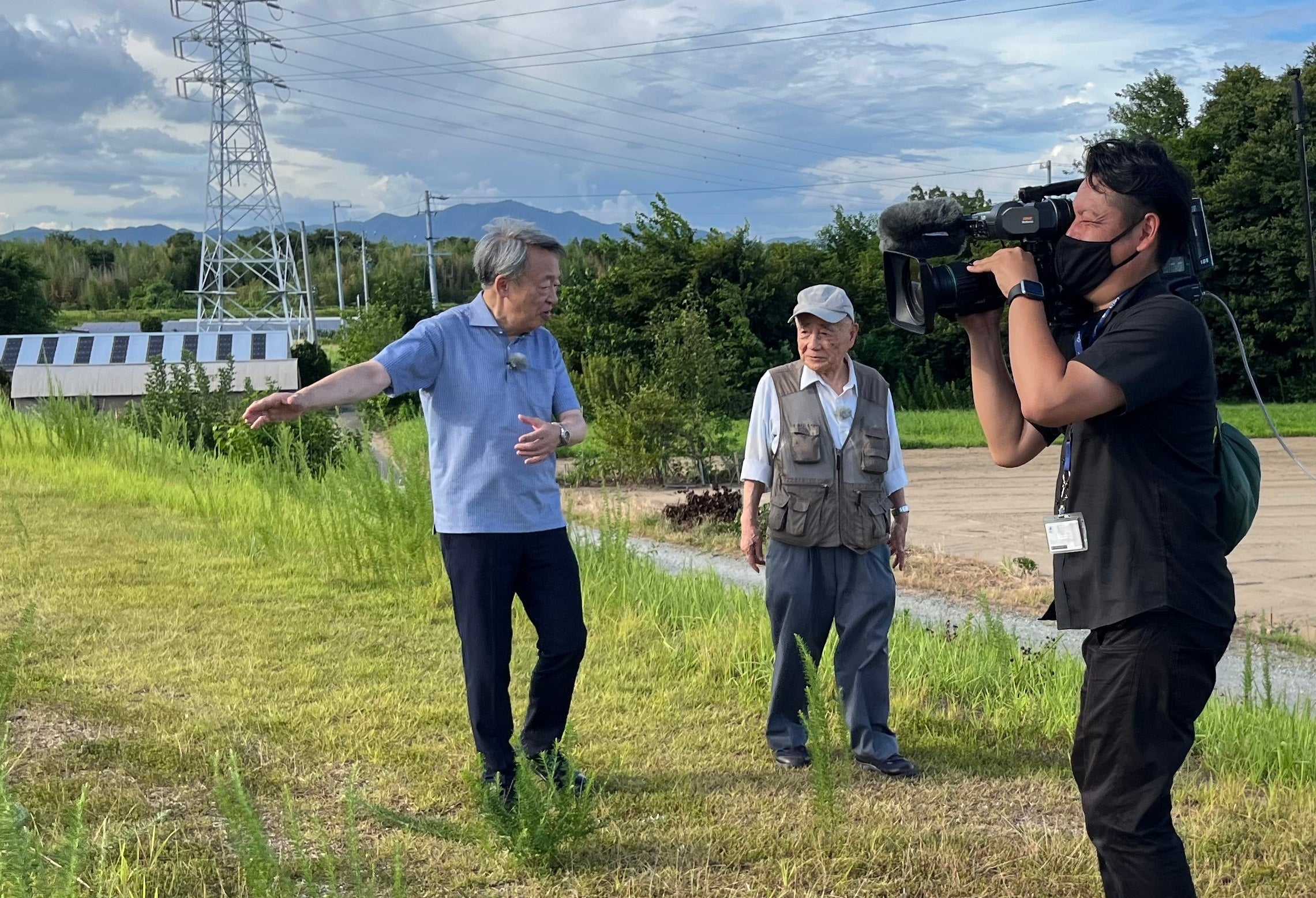 (豊川の「霞堤」で専門家に取材する池上さん)