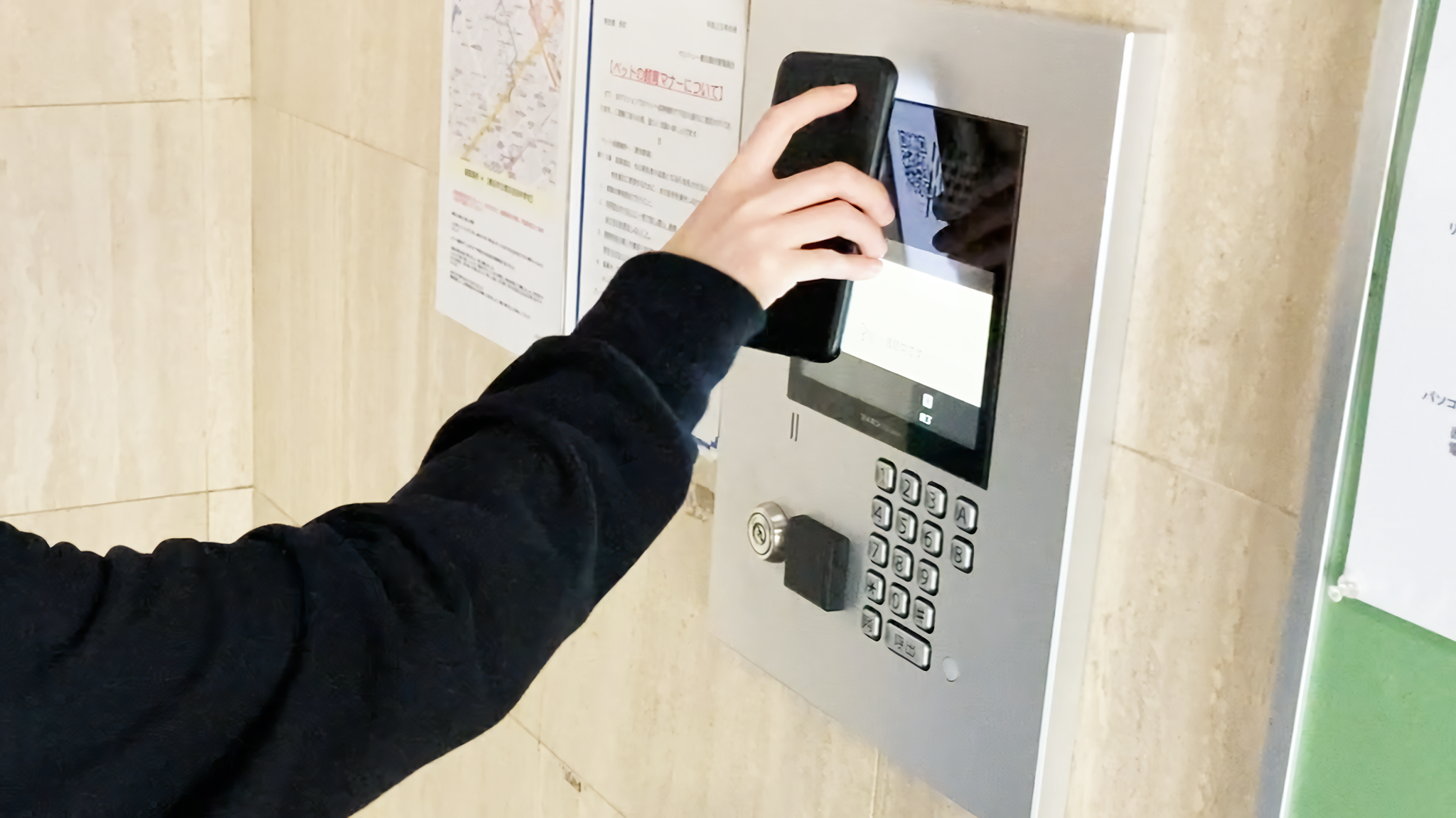マンション共用エントランスのインターホンで内見する部屋を呼出し、専用アプリ「スマビュー」に表示されたQRコードをカメラにかざしてオートロックを解錠