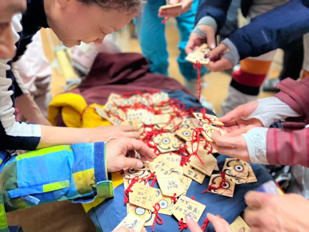 白馬で持参した絵馬を合わせる観光客の様子。