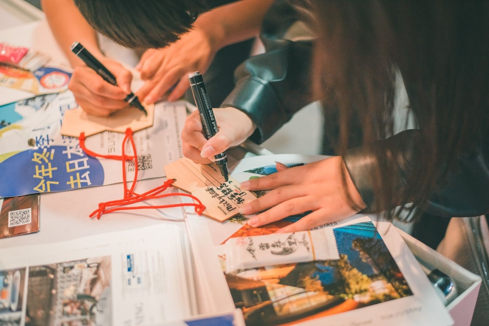 配布したオリジナルの絵馬にメッセージ書く体験参加者。