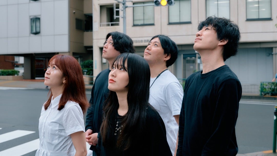 電柱広告を見上げ、希望に満ち溢れた様子の当社社員