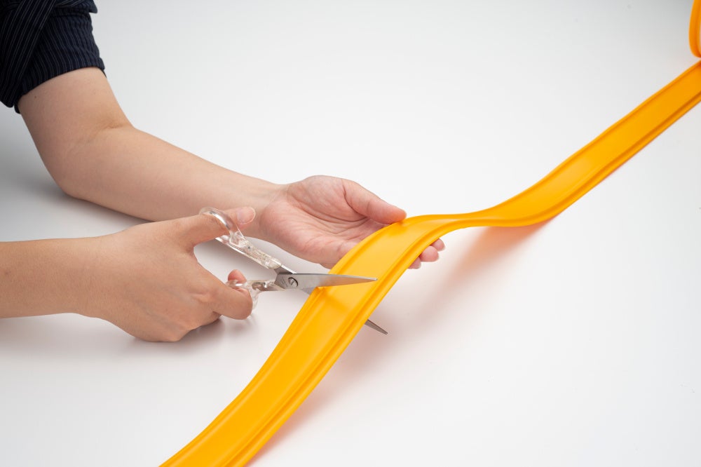 画像の説明：ココテープをハサミで好きな長さにカットしている。