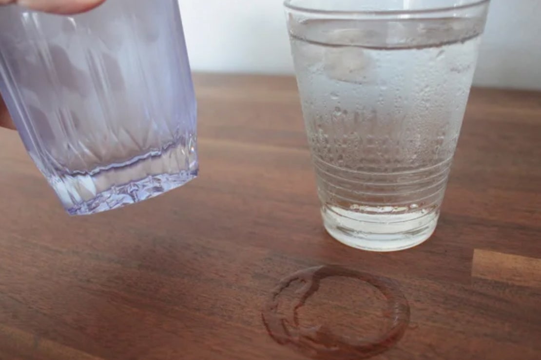 画像の説明:結露していないKINJO JAPANのシリコーングラスを持ち上げ、右側には水滴がテーブルについた、結露したガラスのグラスが右に置かれた様子