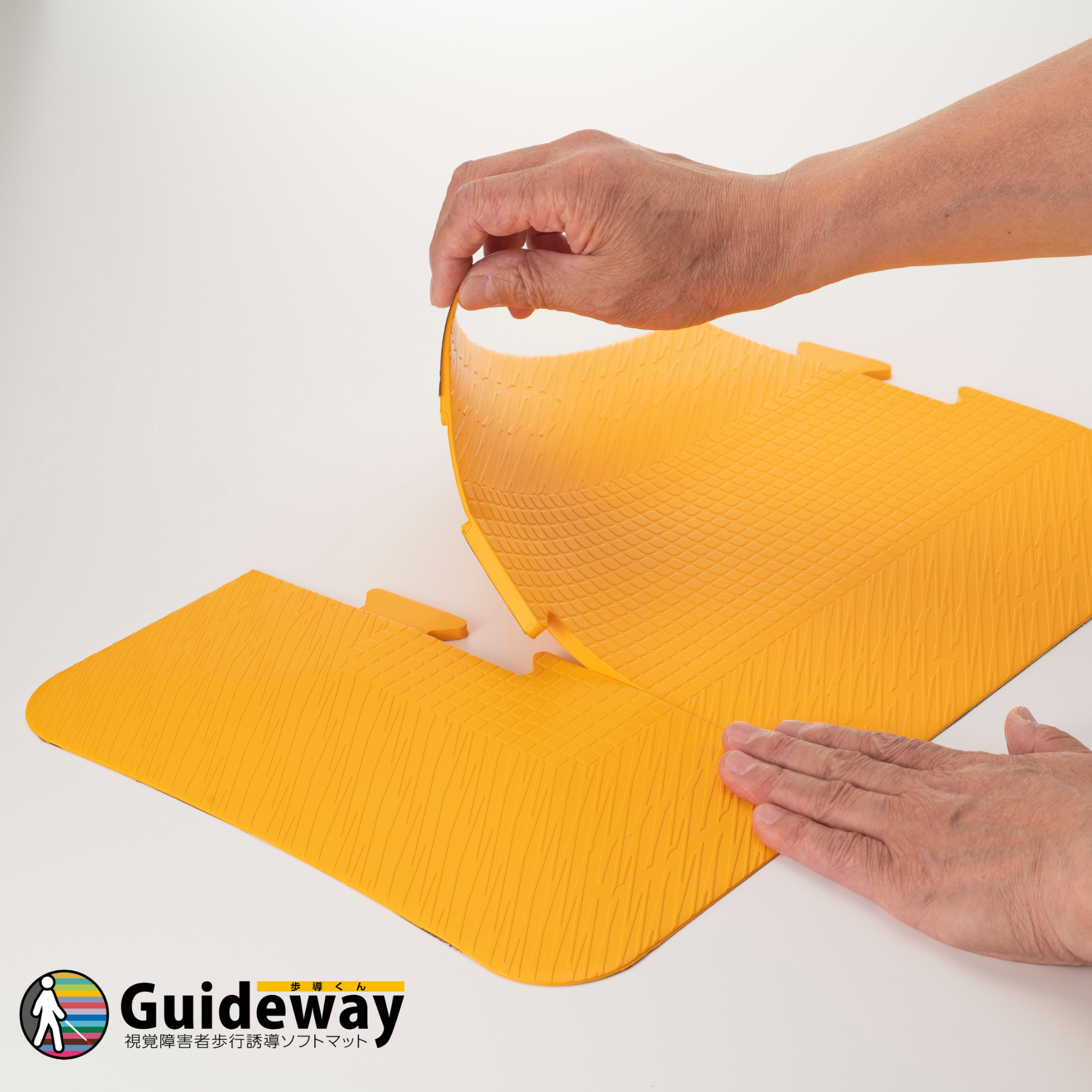 画像説明：両面テープで貼る仕様の「歩導くんガイドウェイ」を設置している様子