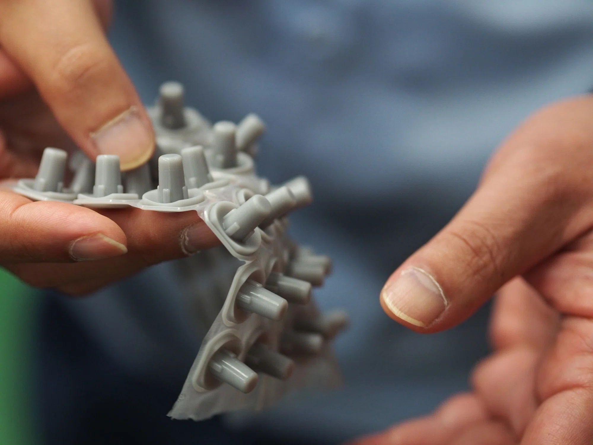 画像の説明：錦城護謨株式会社で製造開発したゴム部品の一部を手に持った様子