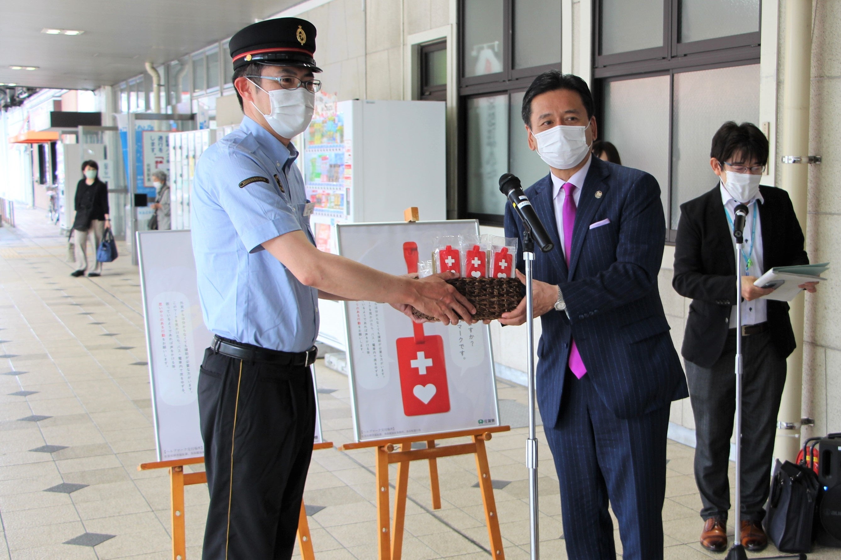 松尾佐賀駅長にヘルプマークを手渡しする山口佐賀県知事