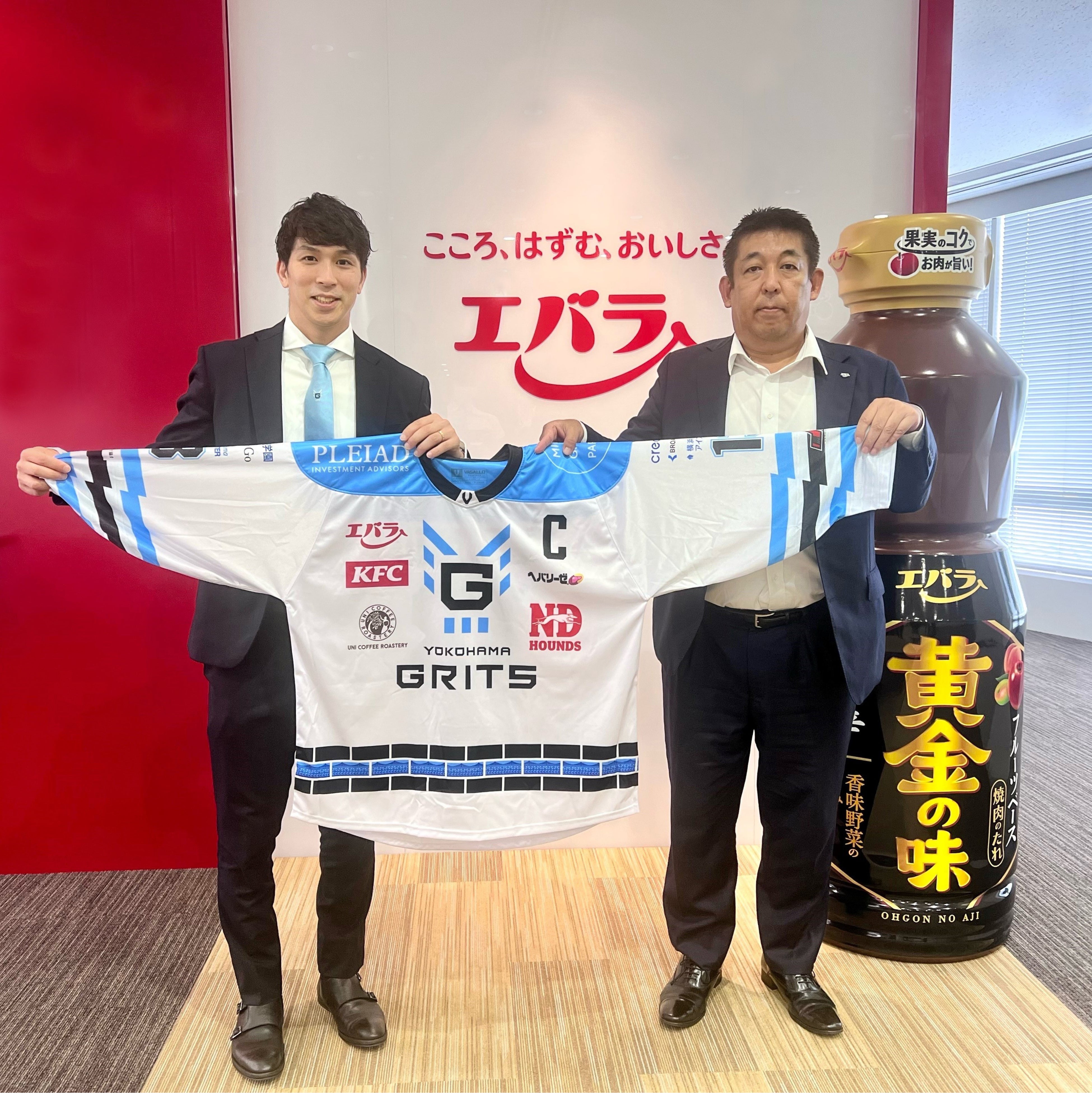 　横浜GRITS 岩本和真キャプテン（左）と一緒にユニフォームを持つエバラ食品  今田勝久取締役（右）