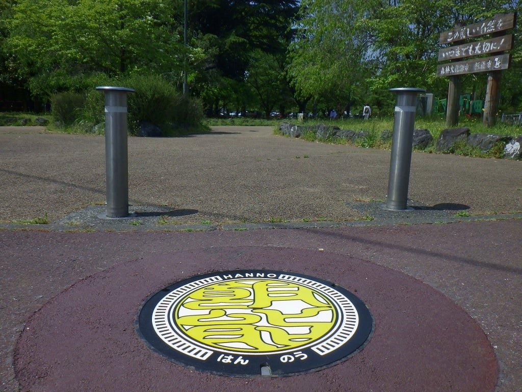 中央公園東側入口に設置した黄文字版の下水道デザインマンホールふた