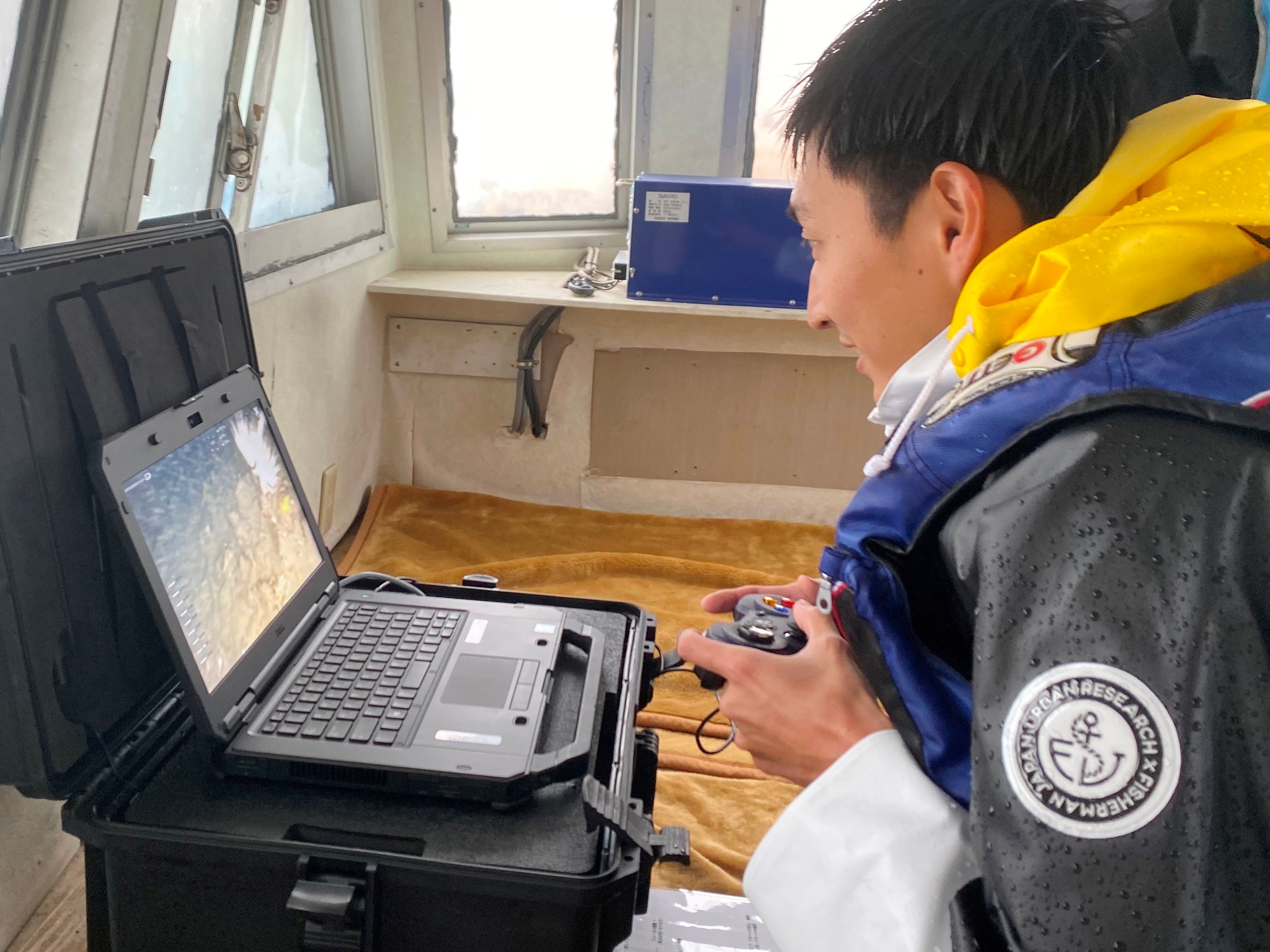 船上で水中ドローンを操作する様子