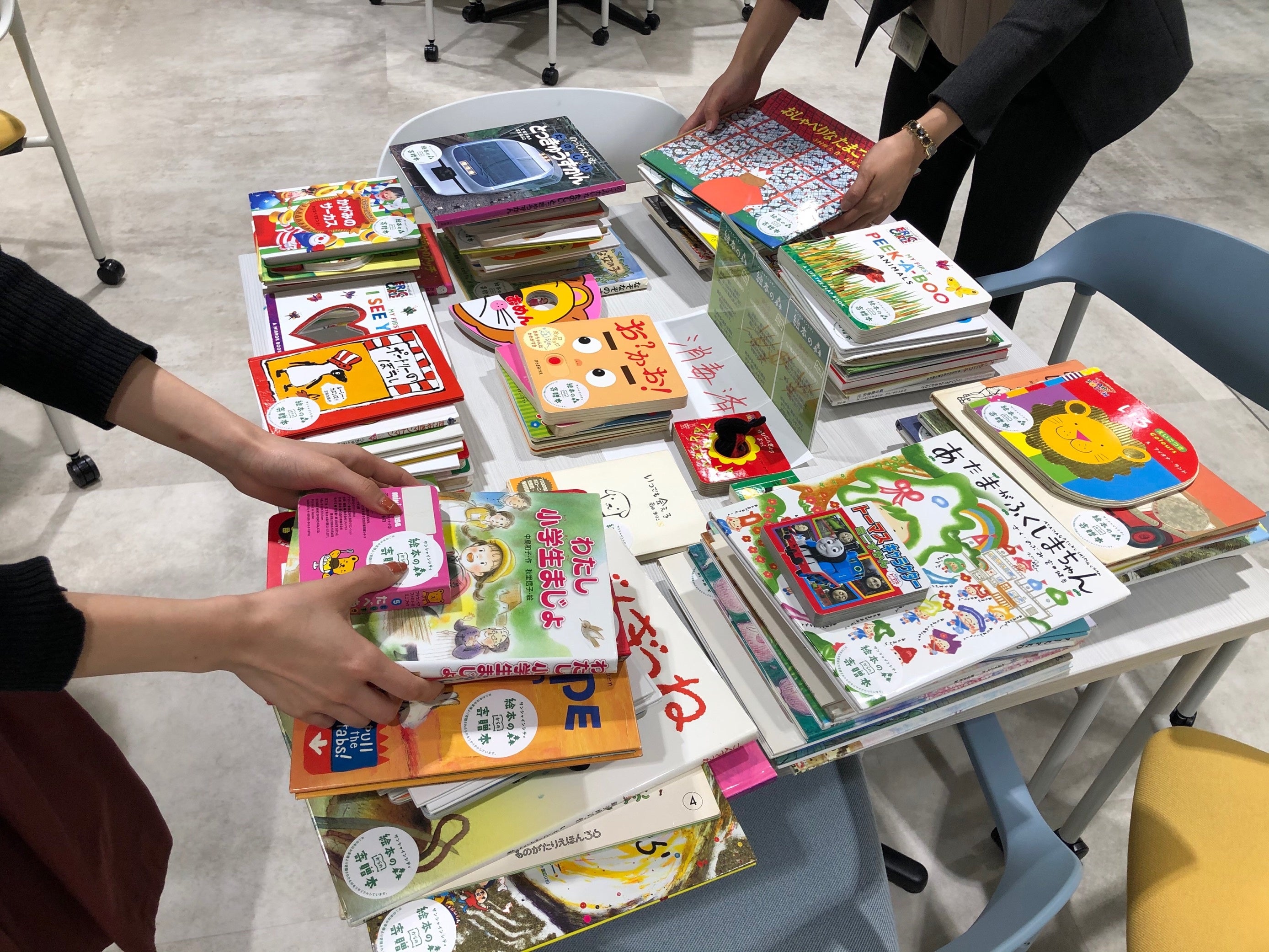 消毒し終わった絵本に寄贈のシールを貼り付け