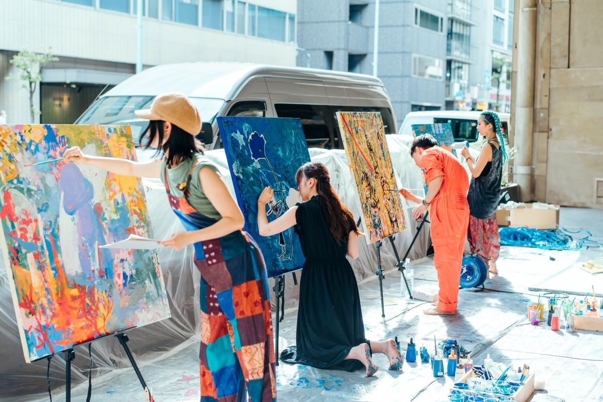 子どもたちが描いたキャンバスにプロのアーティストが作品を仕上げる様子 (過去実施の様子)