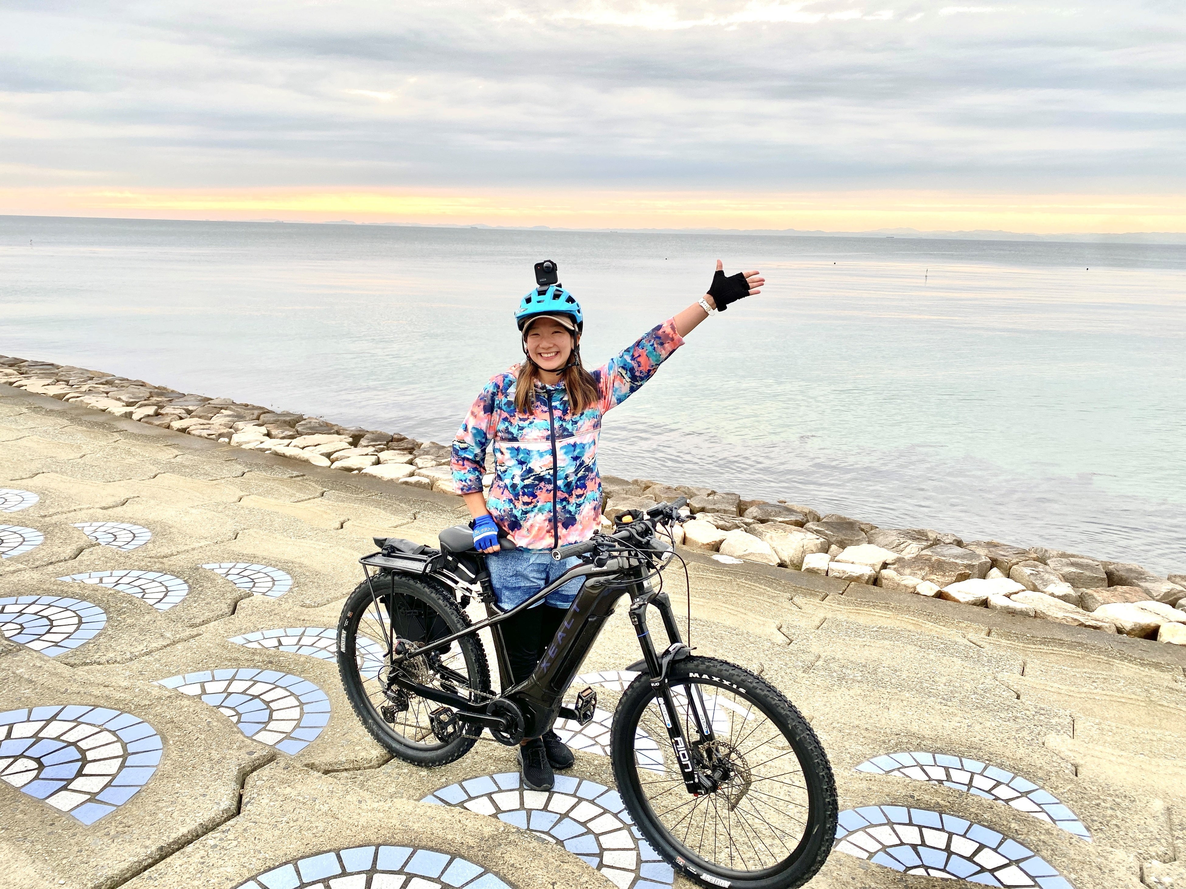 淡路島西海岸の夕陽の前でポーズする平野由香里