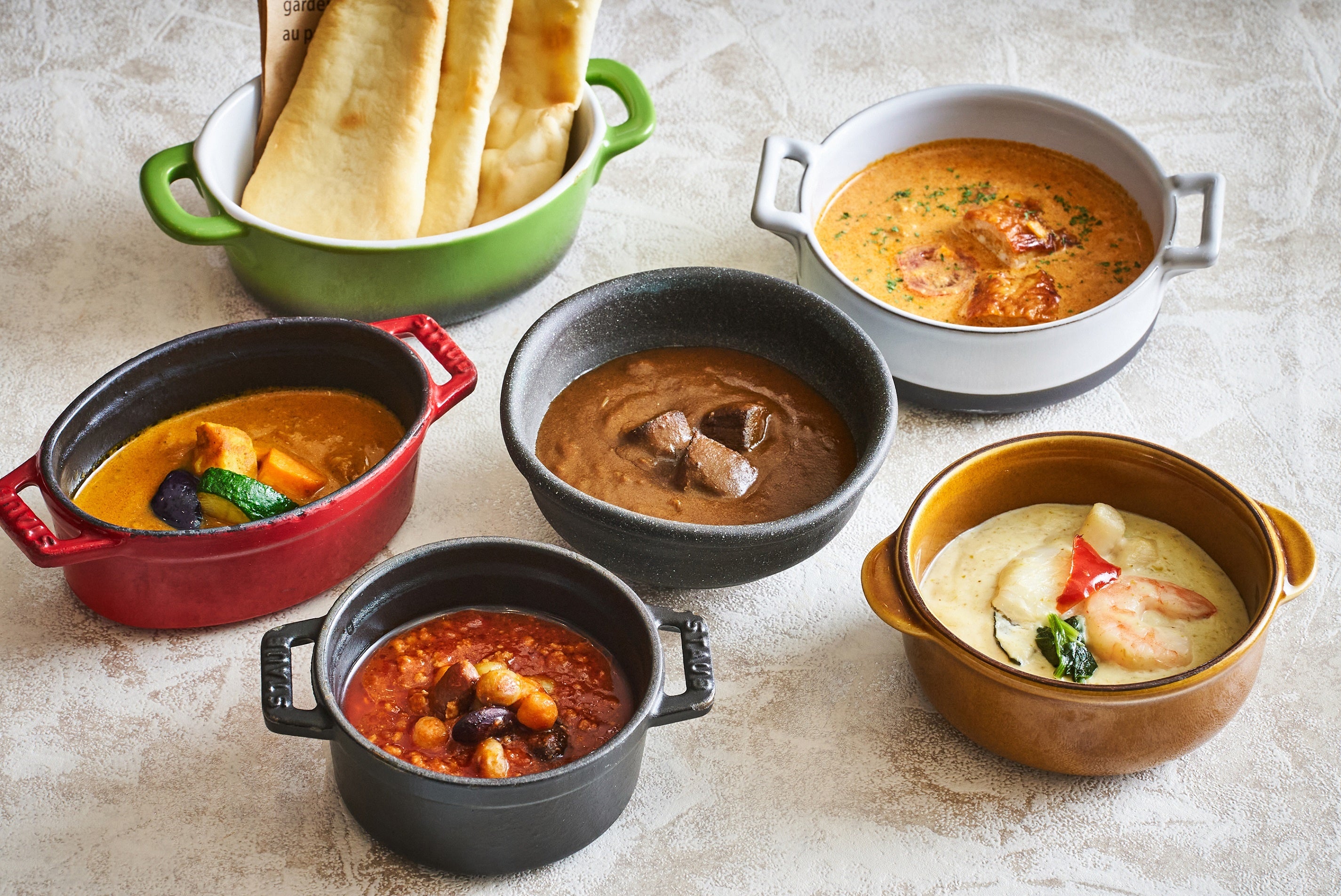 さまざまな味わいの5種のカレー（バターチキンカレー、シーフードグリーンカレー、トマトカレー、 ベジタブルカレー、ハプナカレー※右上から時計回り）