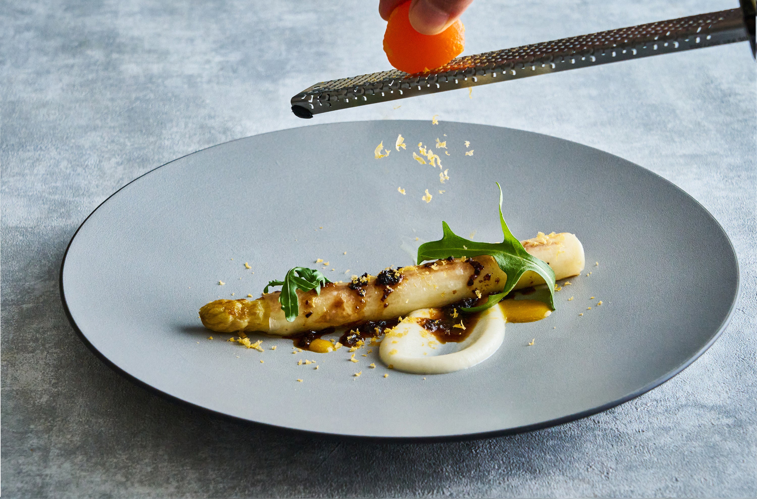 濃厚なトリュフソースと仕上げに削る卵黄の塩漬けがアクセントのホワイトアスパラガスのソテー（DINING & BAR TABLE 9 TOKYO）