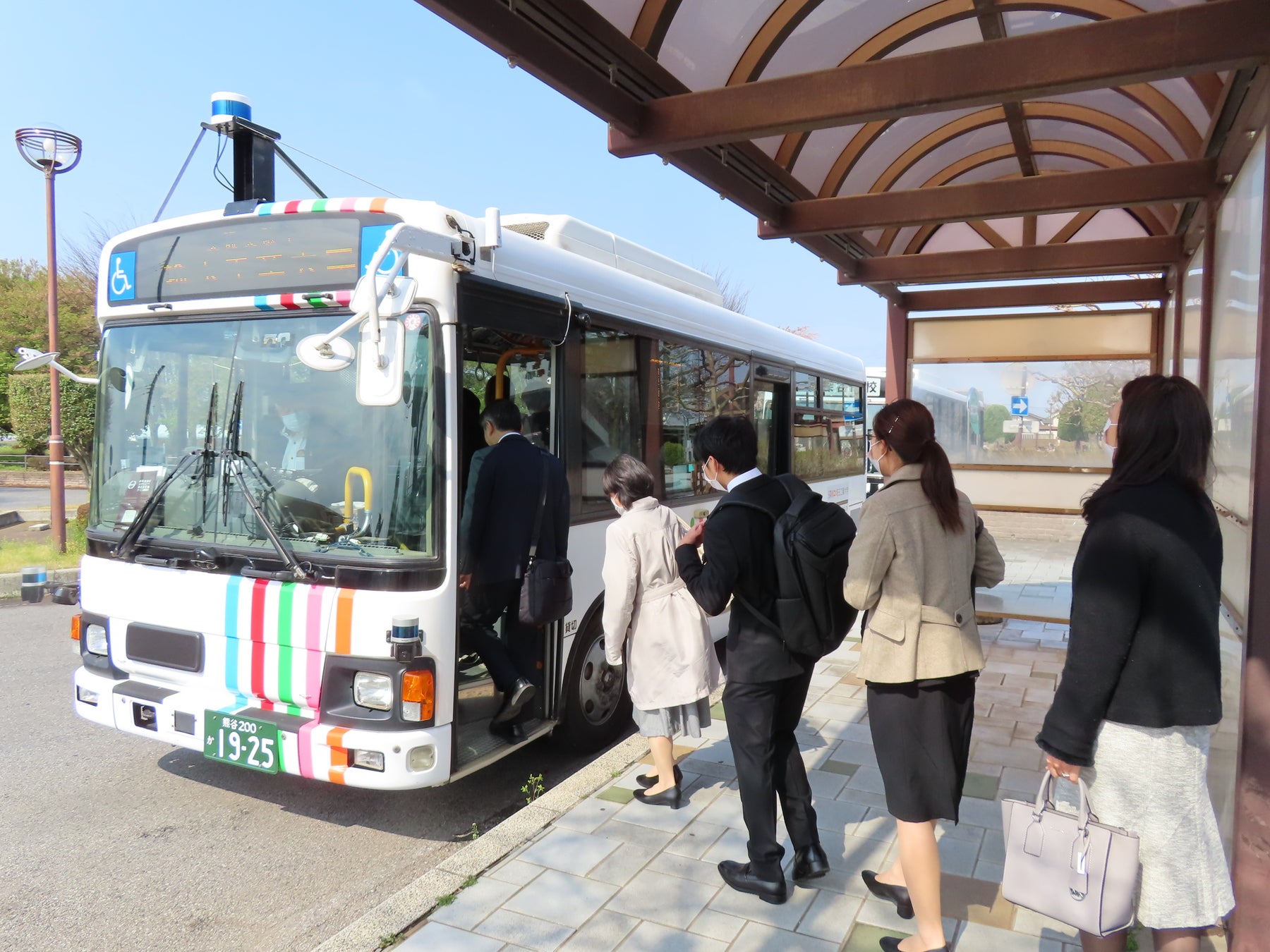 写真２：最寄り駅前から自動運転バスに乗車する新入学生と保護者