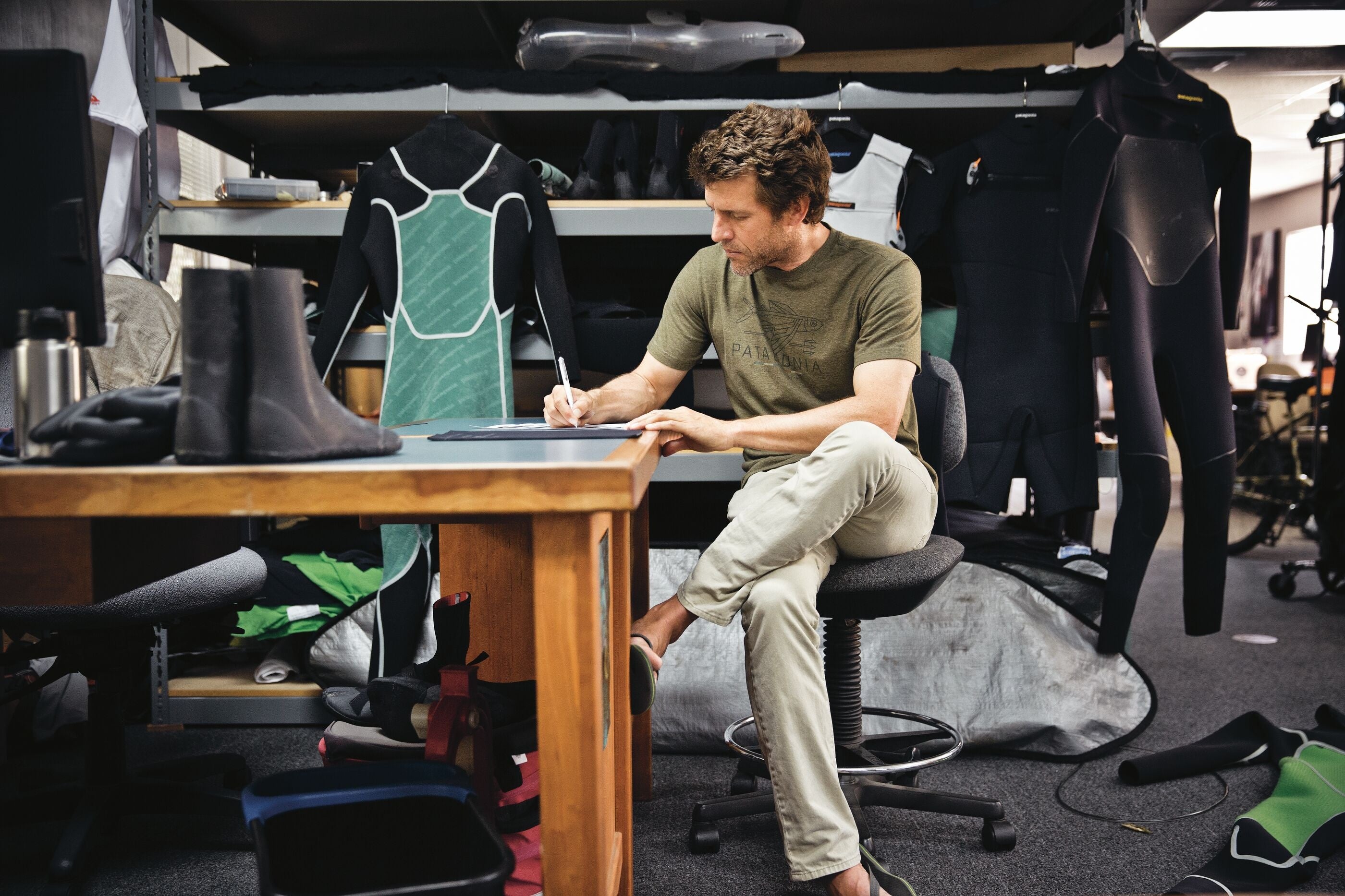 デスクで仕事をするパタゴニアのウェットスーツ・デザイナー、ハブ・ハバード。(カリフォルニア州ベンチュラ)　© Tim Davis