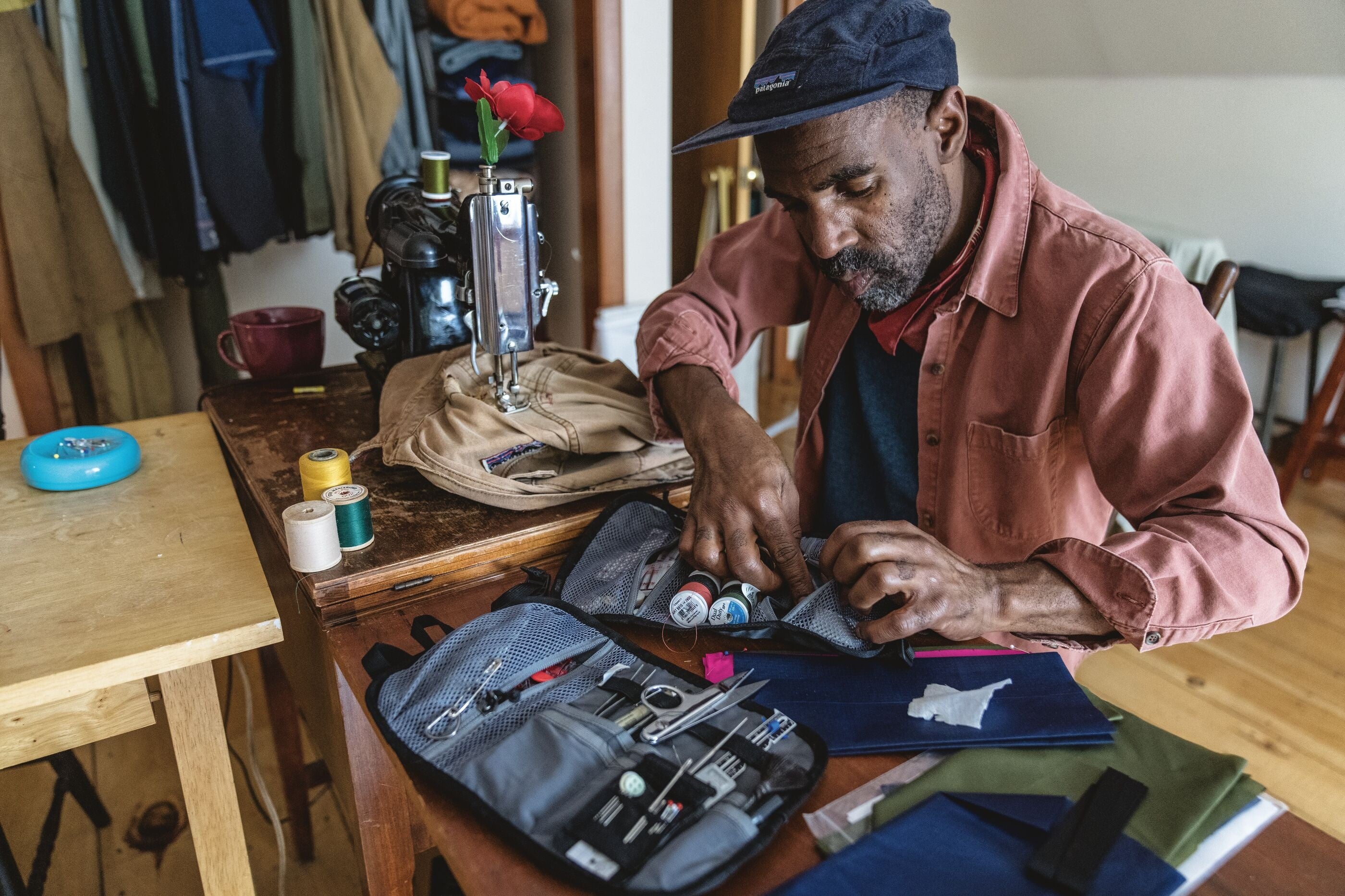 リユースセンター長に就任したアーティスト、フレッド・ホワイト。写真は、前職のニューヨーク店長時代にビンテージ衣料を修理しているところ。© Drew Smith