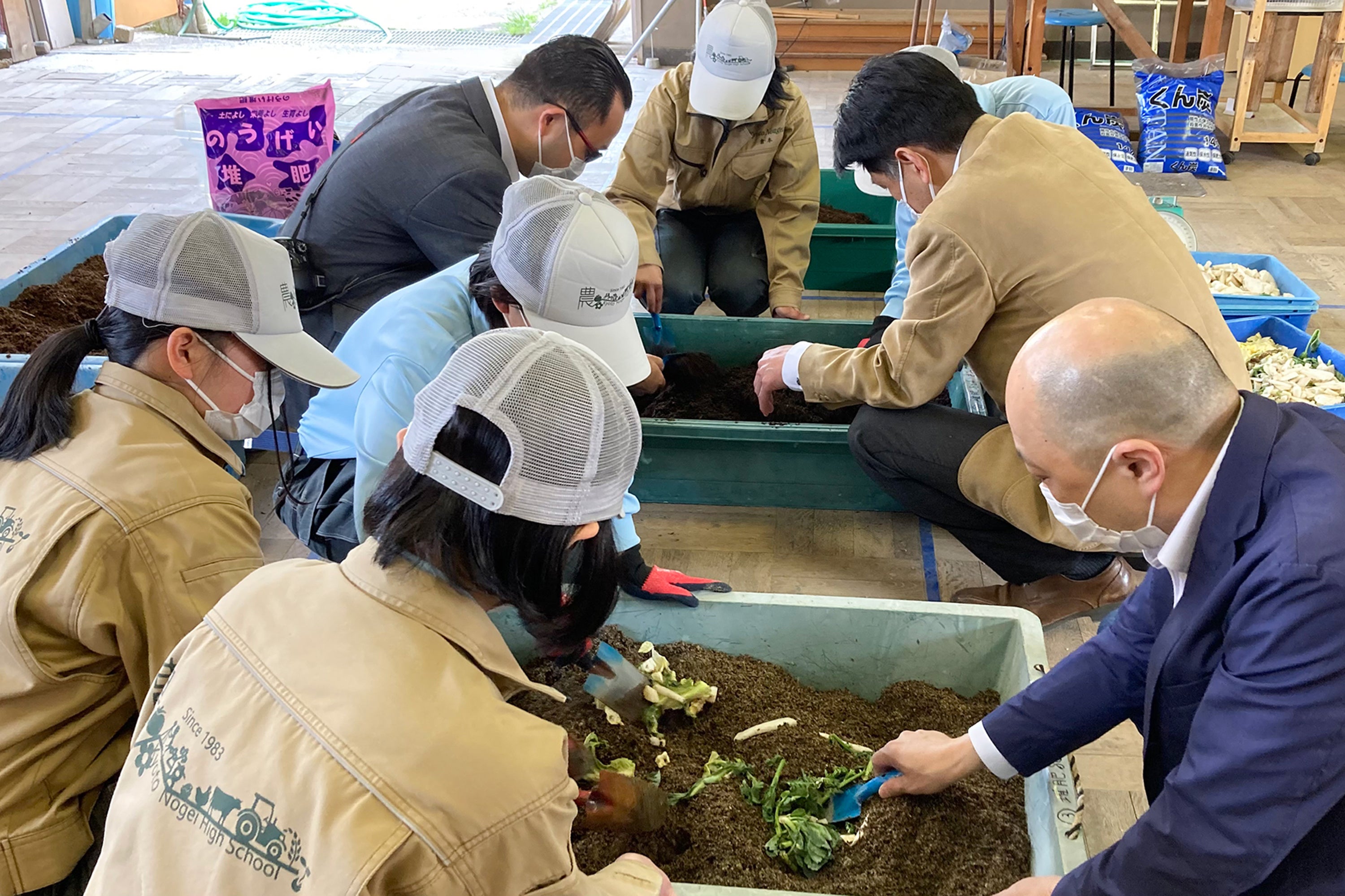 農芸校生から堆肥作りのレクチャーを受けるホテルスタッフ