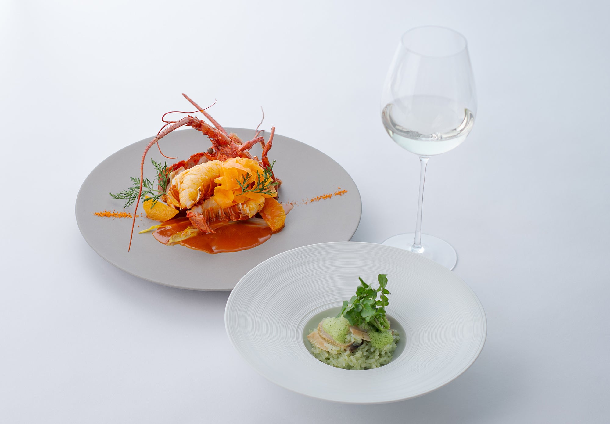 （左）「伊勢海老のソテー 柑橘のソース」、（右）「ハマグリのリゾット」