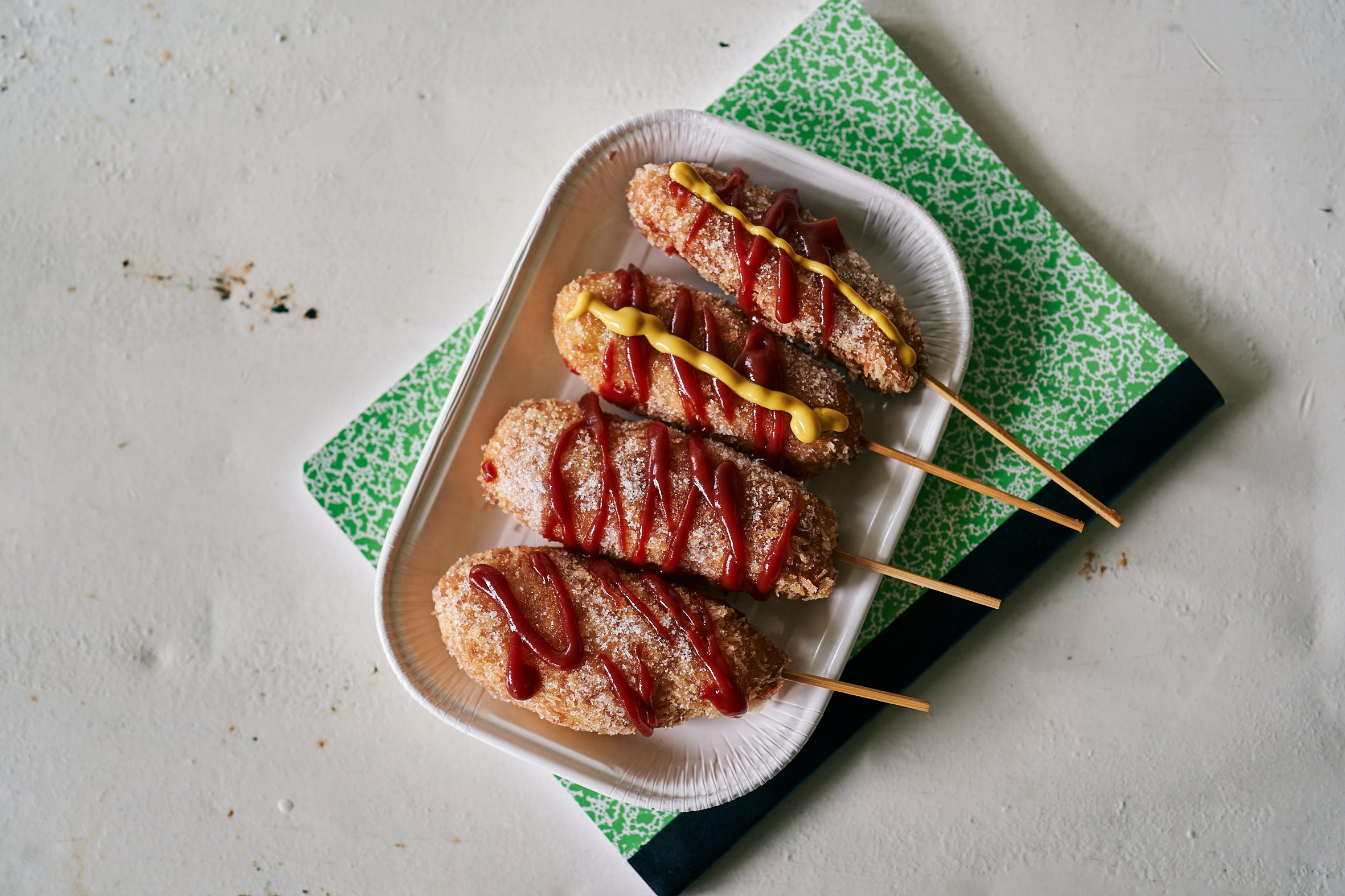 ソーセージとさけるチーズで作れる「ハットグ」。グラニュー糖をまぶしてからケチャップとマスタードを！やみつきになるおいしさです。