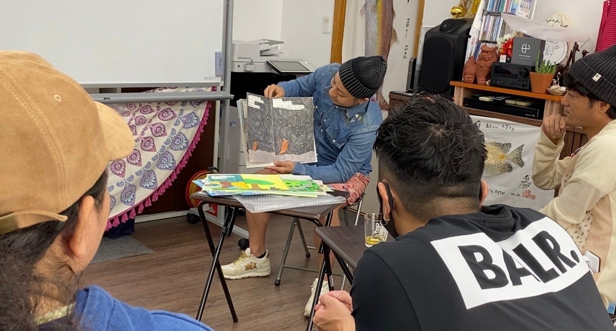 HYメンバーに絵を披露する名嘉さん。