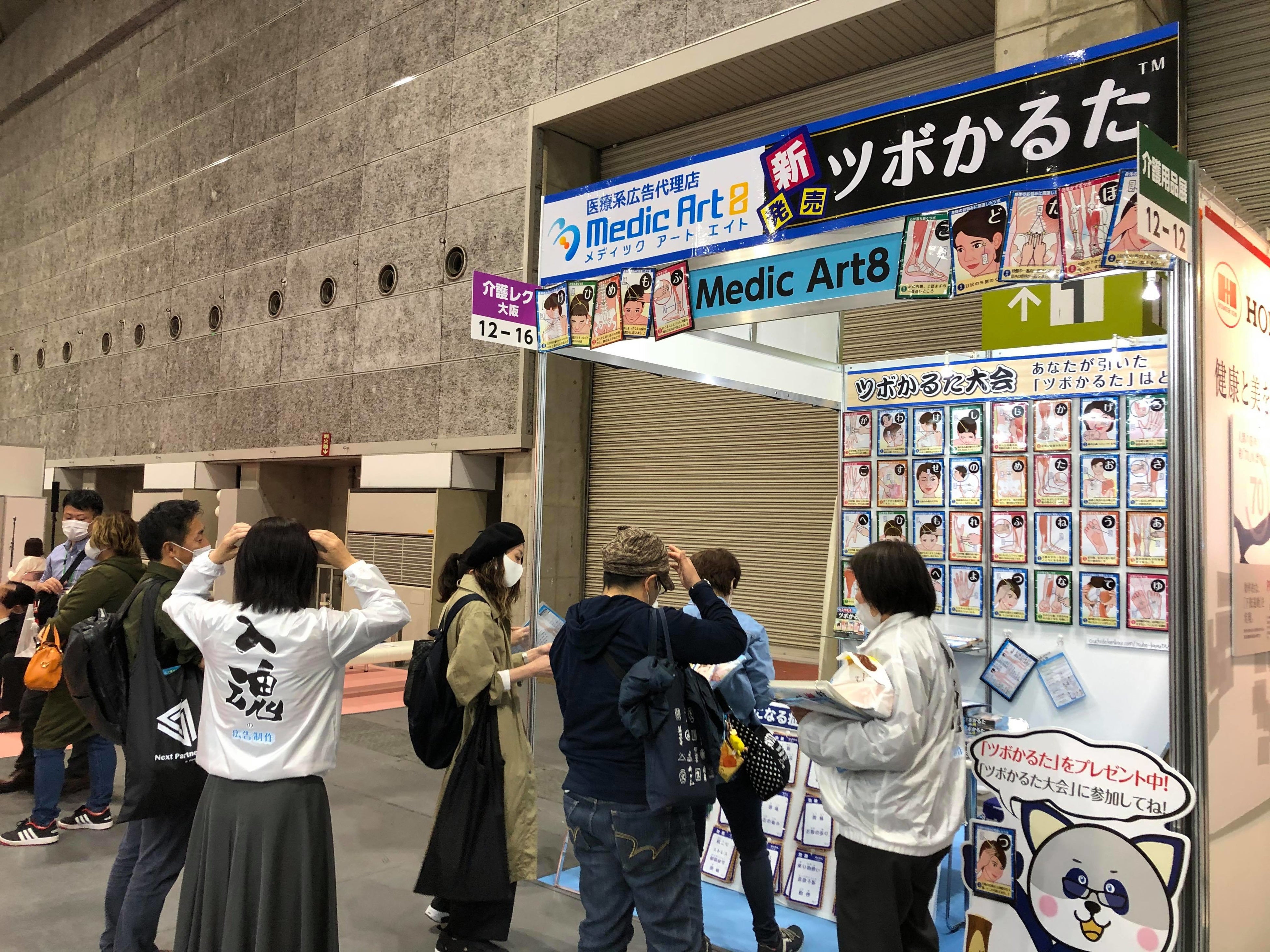 展示会のブース内で行なった「ツボかるた大会」で『ツボかるた』を試す人たち。