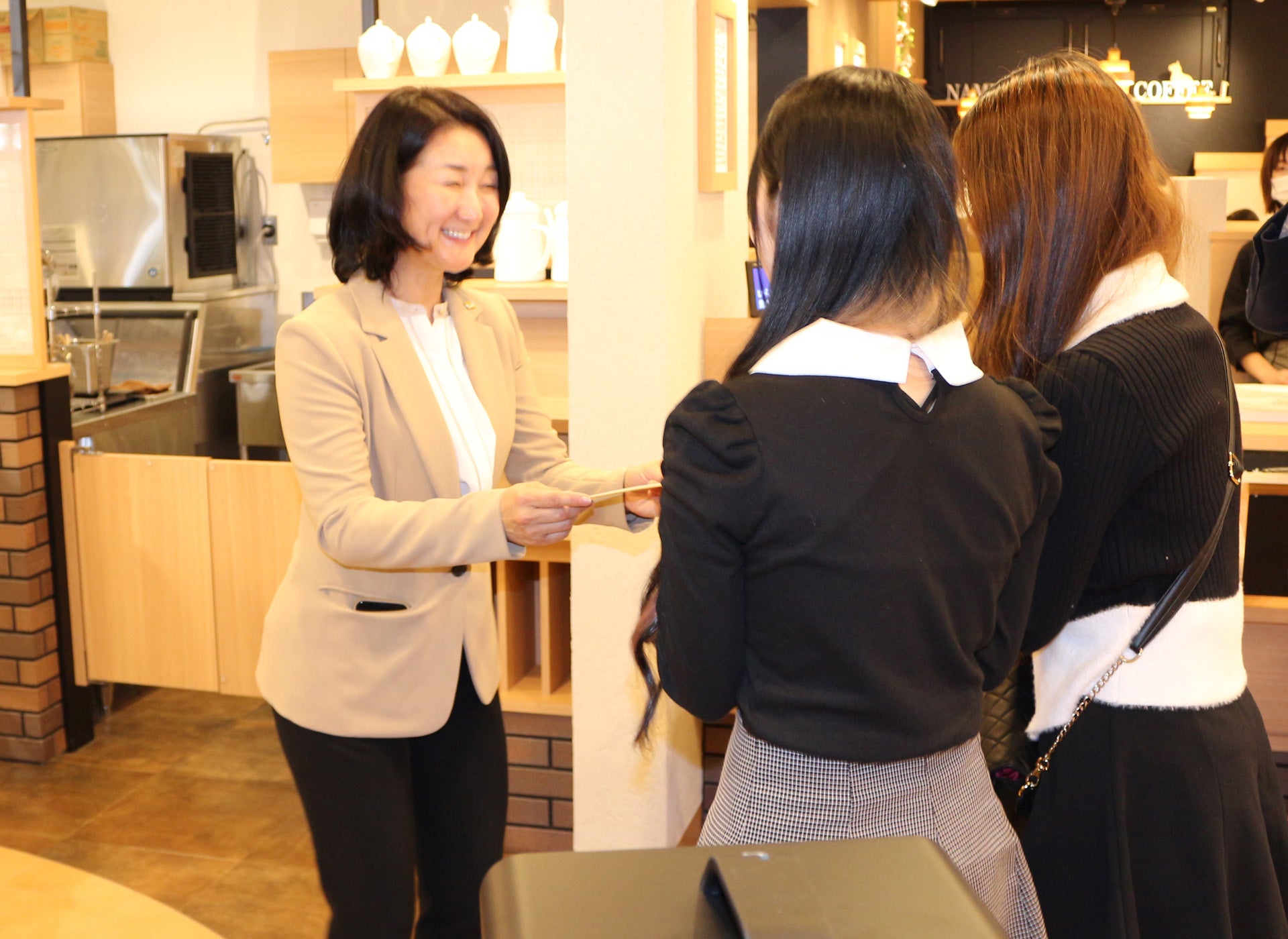 参加者から感謝のメッセージが書かれた、 寄せ書きを受け取る、当社代表取締役社長 穴見くるみ