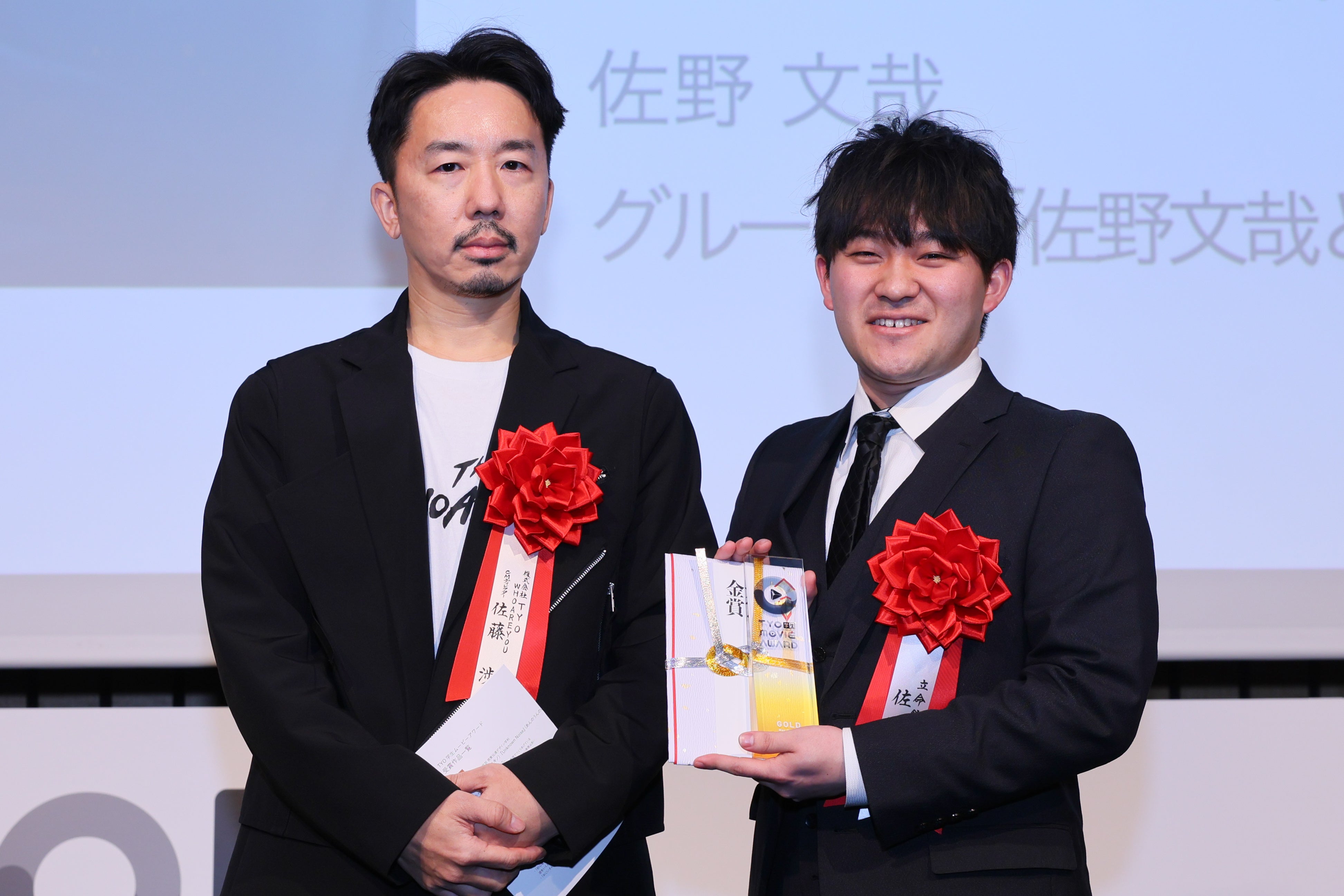 左から審査員の佐藤 渉(TYO)、金賞受賞の佐野 文哉さん