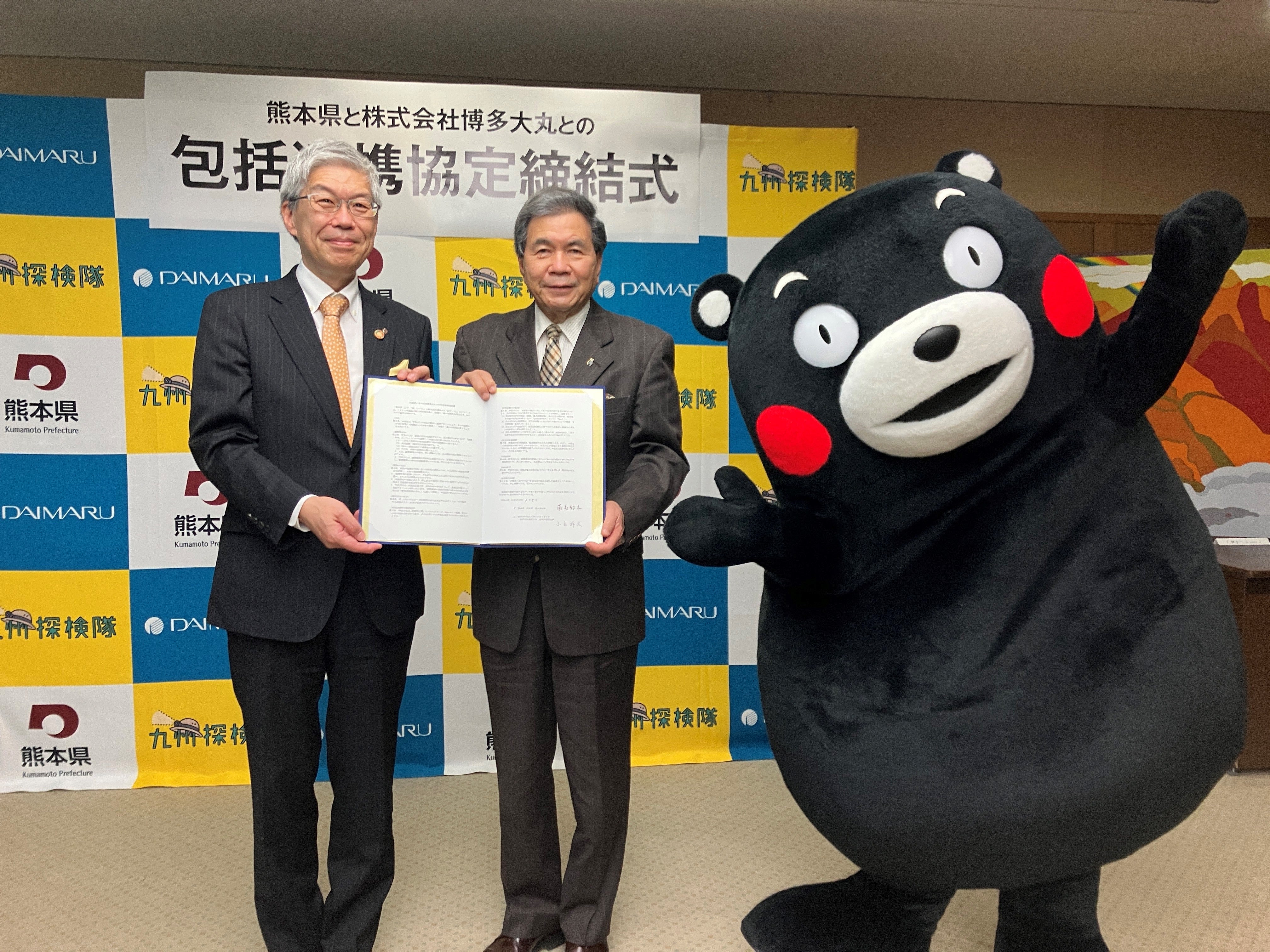 ▲左から㈱博多大丸代表取締役社長小宅祥広、熊本県知事蒲島郁夫、熊本県営業部長兼しあわせ部長くまモン