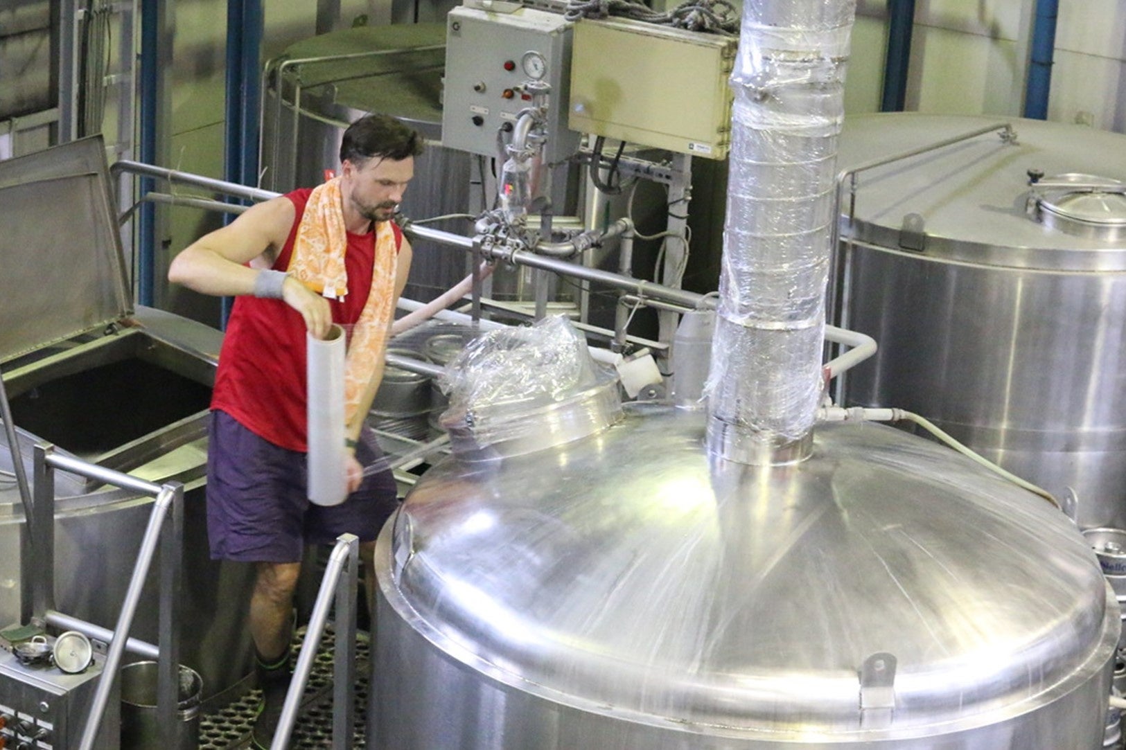 フィルムで釜を覆い乳酸菌の拡散を防ぐ作業