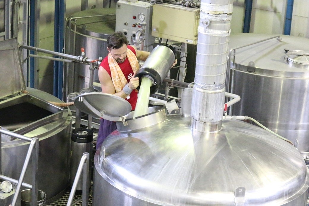 ホエイを釜に投入するブルワーのベン