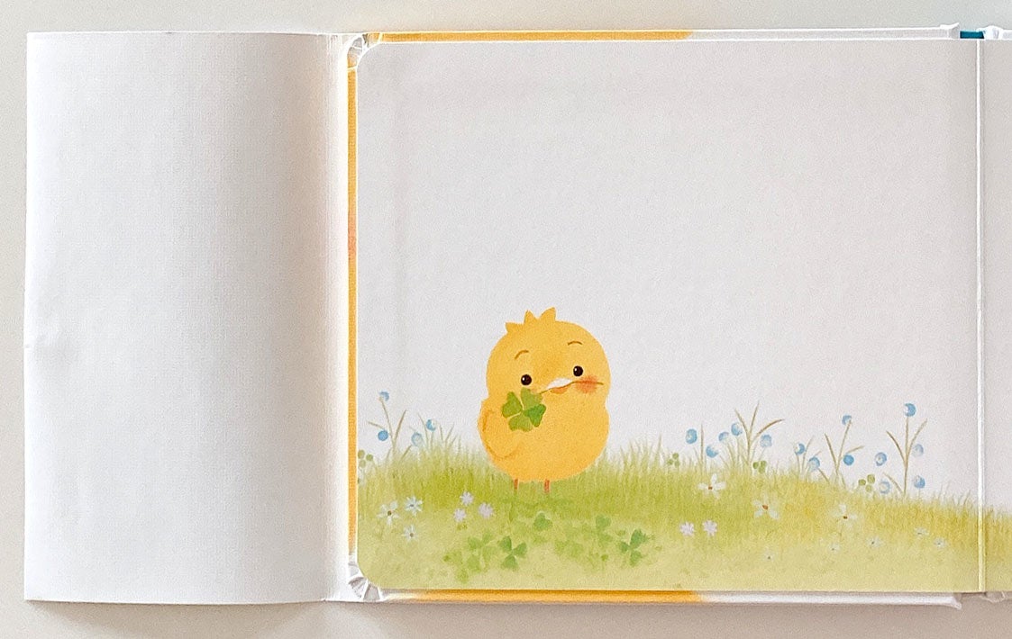 ▲『ぴよちゃんの おかあさん どこ？』表紙カバー部分。カバー袖をめくると…ぴよちゃんが四つ葉のクローバーをたった今、つんだのでしょうね。くわえています