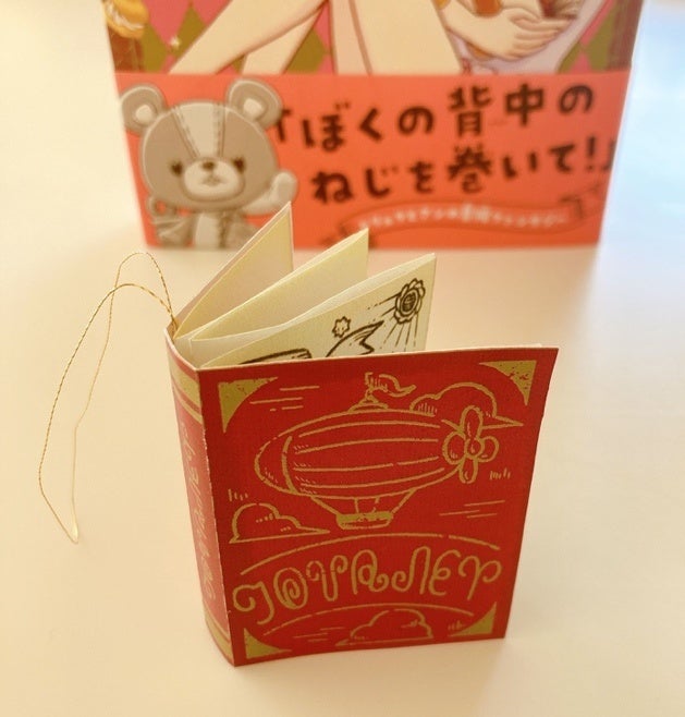▲『ぜんまいじかけのトリュフ』ノベルズ公式サイト　OMAKE通信内データをダウンロードして作れるペンダントブック。ヒモは自分でつけてくださいね。ペンダントにするにはもう少し長いひもにしてくださいね