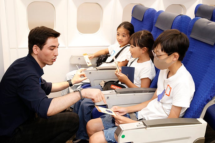 TGG BLUE OCEANの人気アトラクション・エアプレインでは、 搭乗券に指定された時間に行くと飛行機に搭乗できる。 機内はまるで本物の飛行機そのもの。客室乗務員の話をよく聞いて、機内でのやりとりに挑戦！