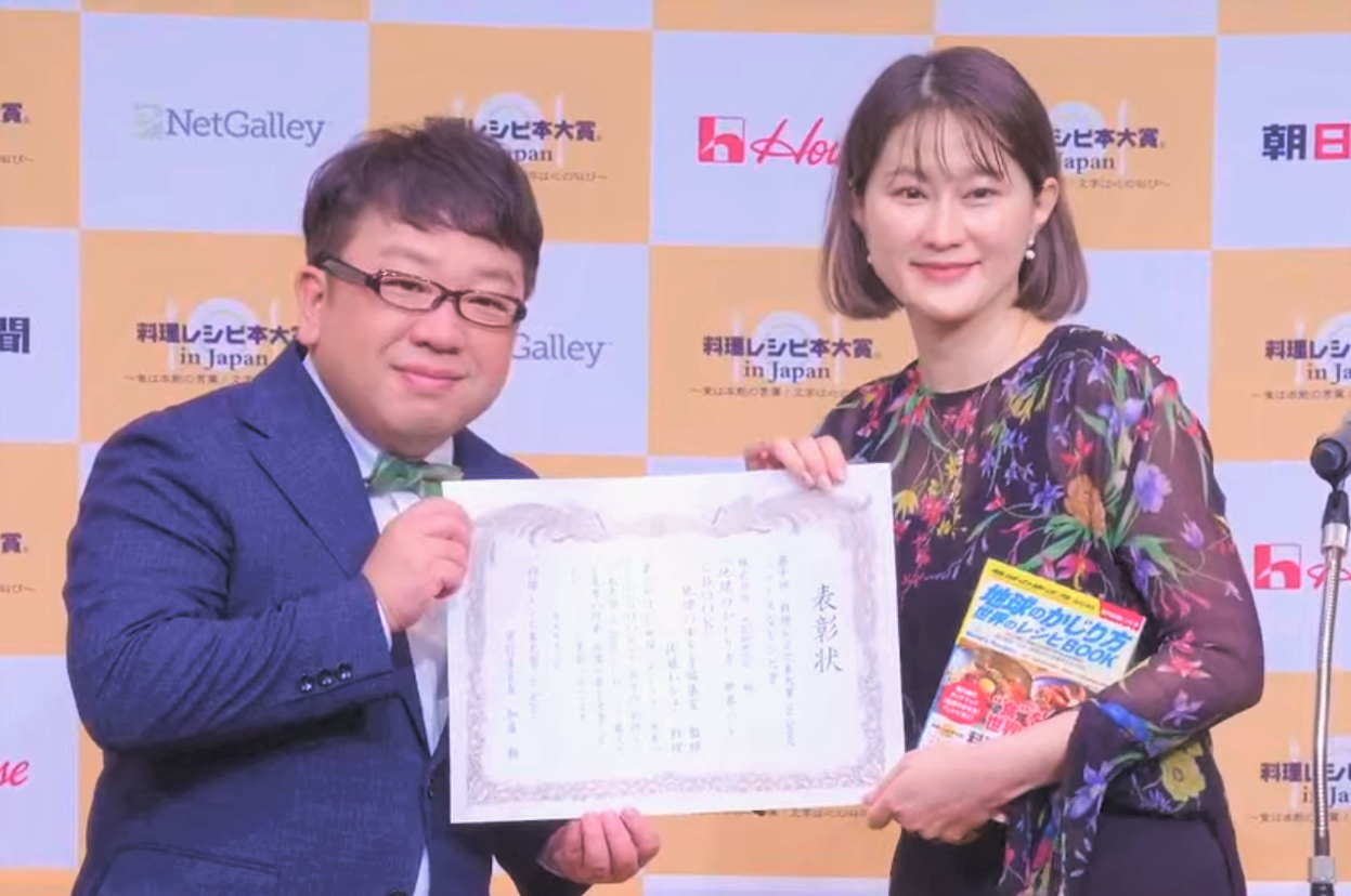 ▲アンバサダーを務める天野ひろゆきさんから賞状を受け取る「地球の歩き方」の日隈理絵さん