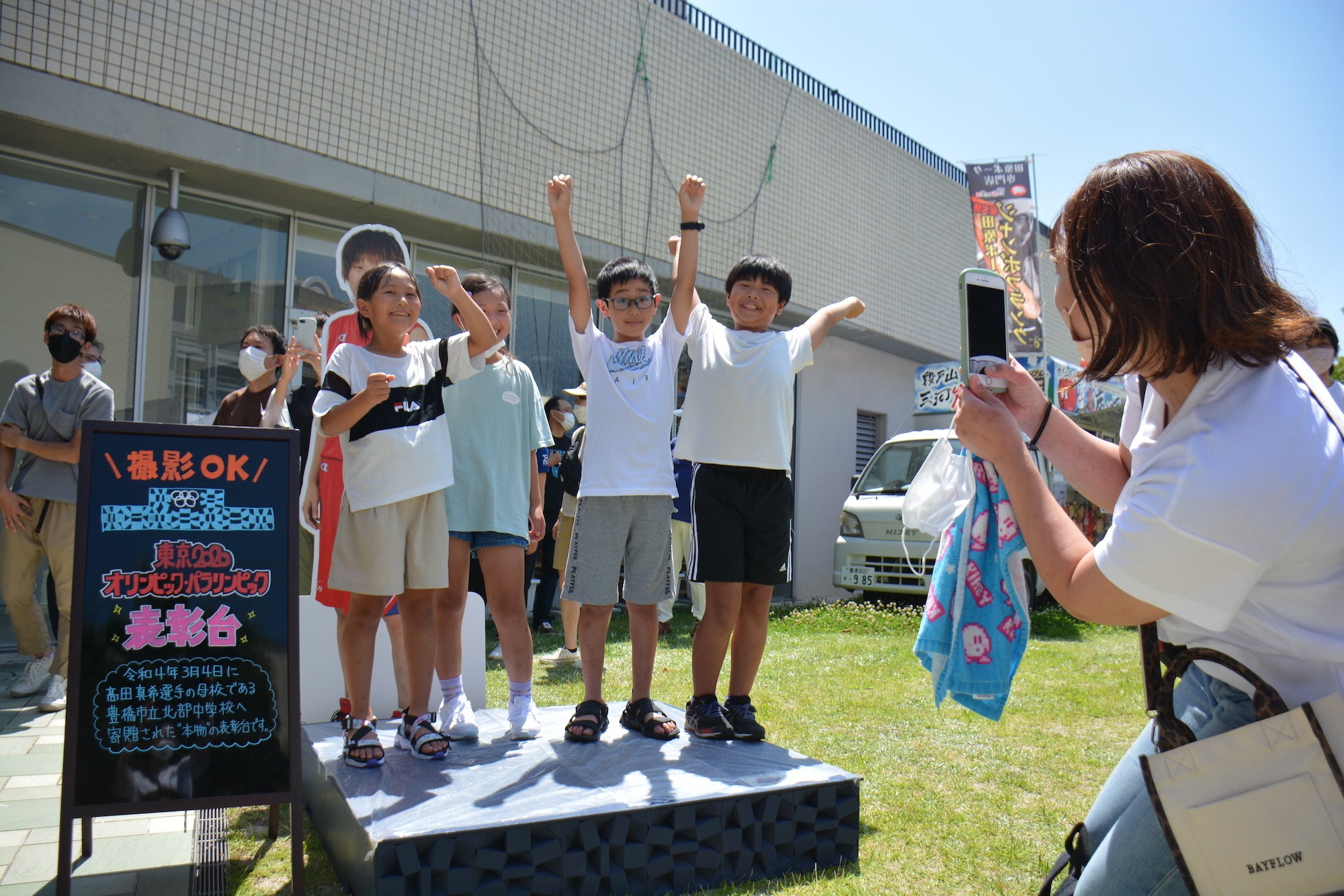 表彰台でポーズをとる子どもたち